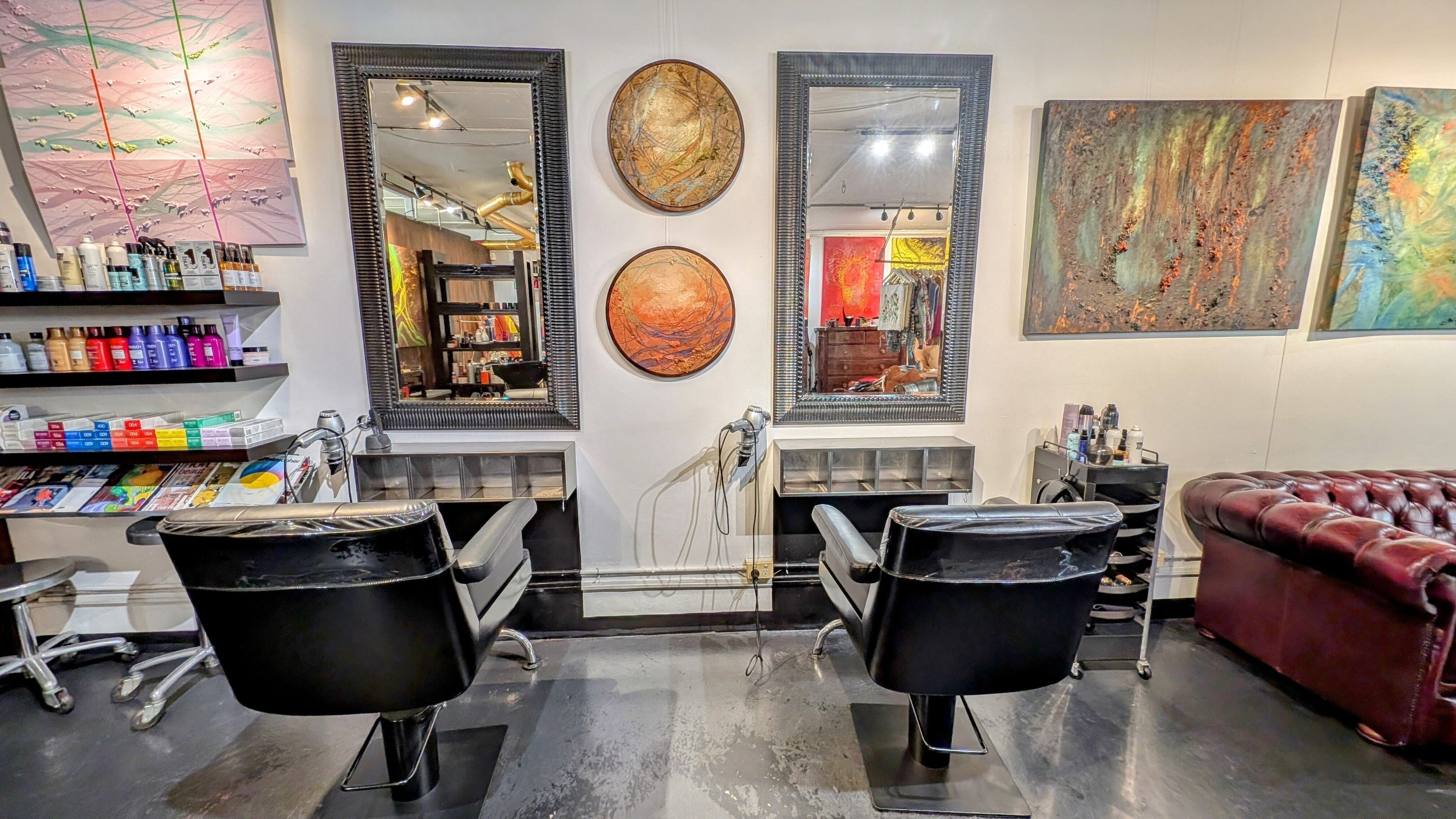 Stylish salon chairs at Ambo Ars, Newtown, New South Wales, AU with modern art and hair care products.