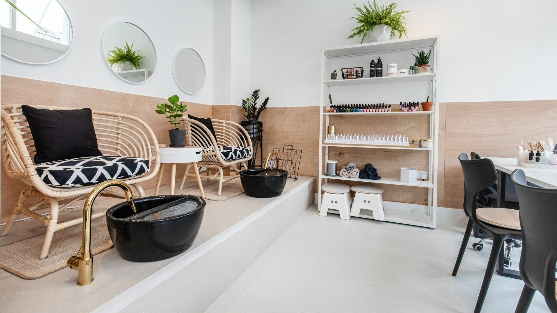 Relaxing spa area at Plaster Beauty in London, England, GB with wicker chairs and a pedicure station.