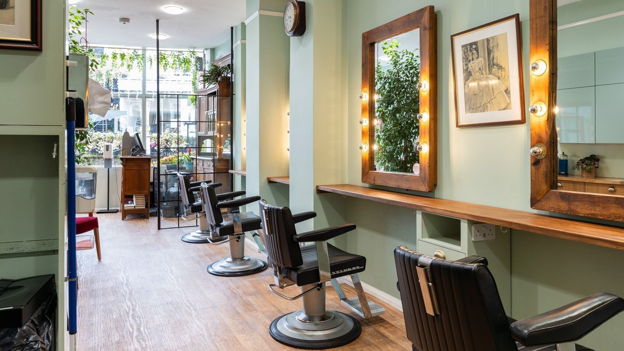 Stylish interior of Lisa Hauck salon in London, England, GB with vintage mirrors and barber chairs.