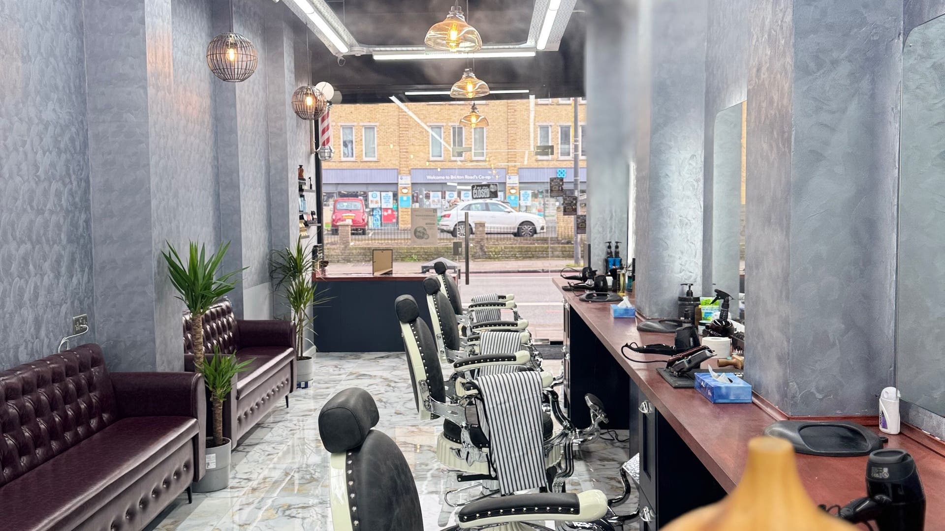 Modern interior of BRIAR BARBERS & Hairdresser in London, England, GB, featuring stylish chairs and decor.