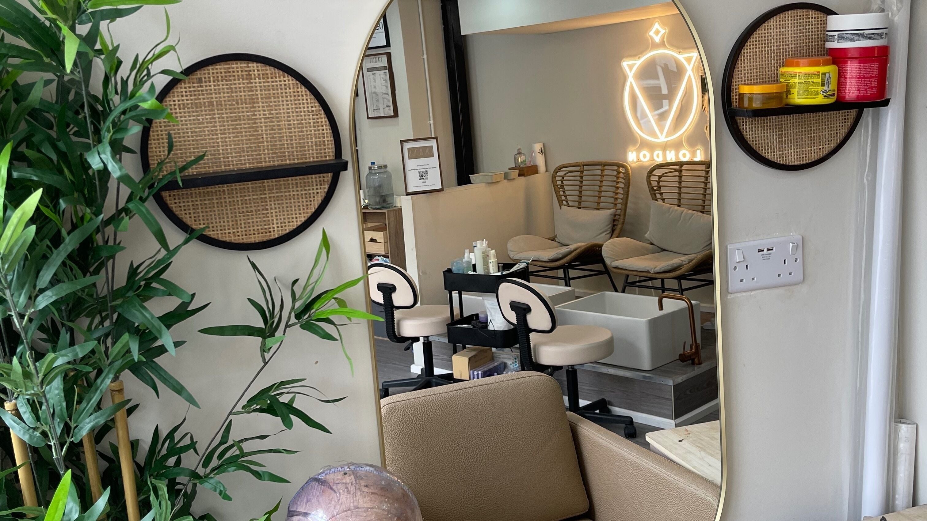 Elegant salon interior at Ovieya London Ltd, London, England, GB. Features cozy seating and lush greenery.