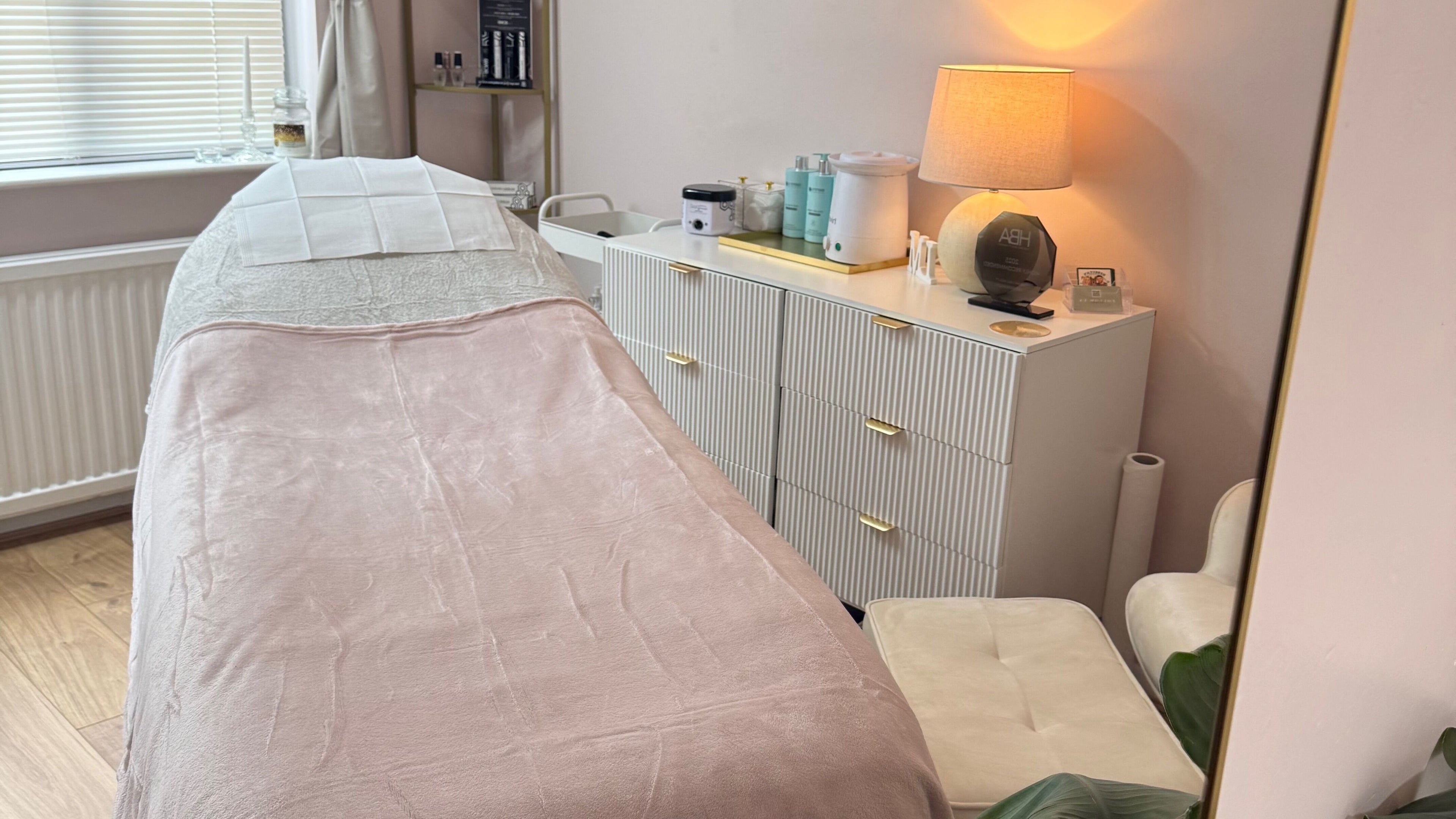 Cozy treatment room at LM Natural Beauty, Sileby, England, GB, featuring a tranquil bed and elegant decor.