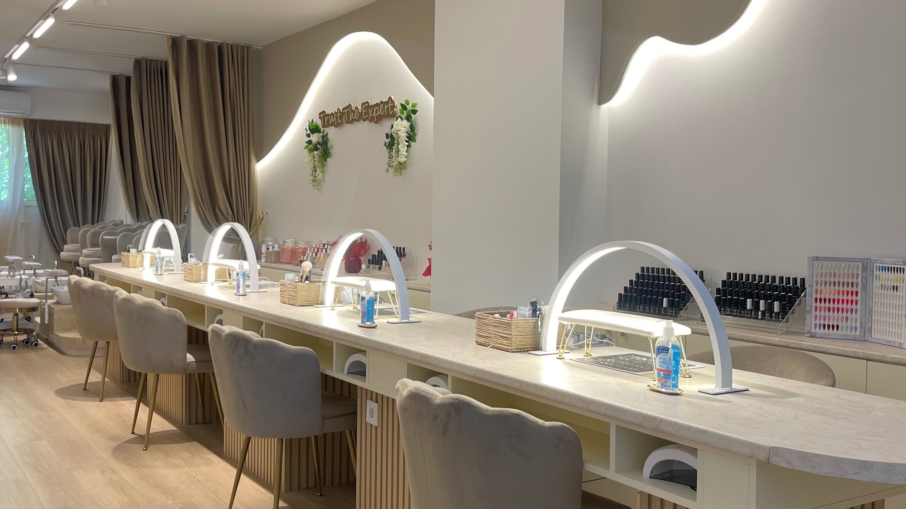 Εσωτερικό του IZEL NAILS & BEAUTY στο Περιστέρι, GR με κομψό ντιζάιν και μοντέρνους πάγκους περιποίησης.
