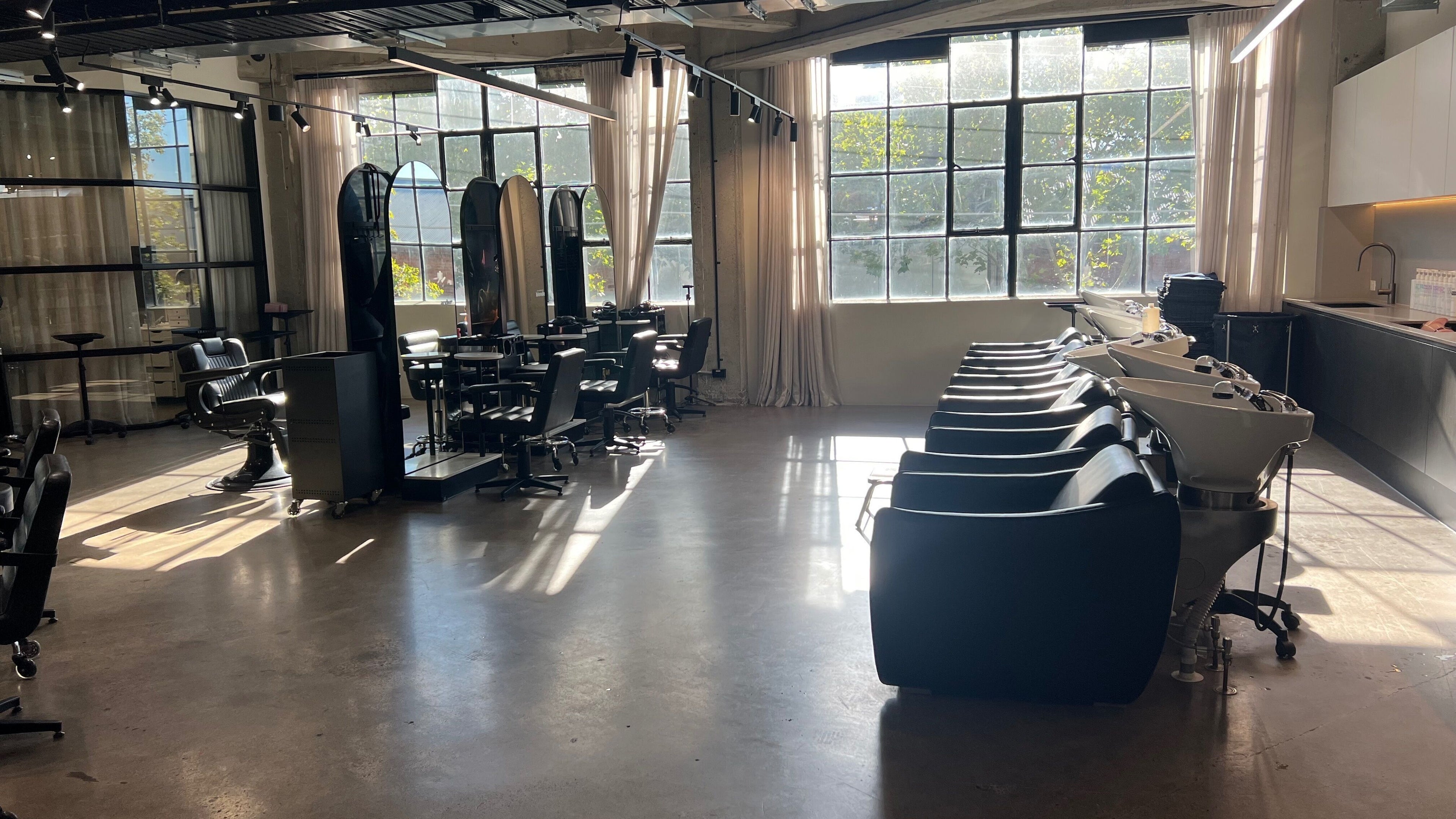 Sophisticated salon layout at Jay'd Irene in Melbourne, Victoria, AU, featuring sleek styling chairs and large windows.