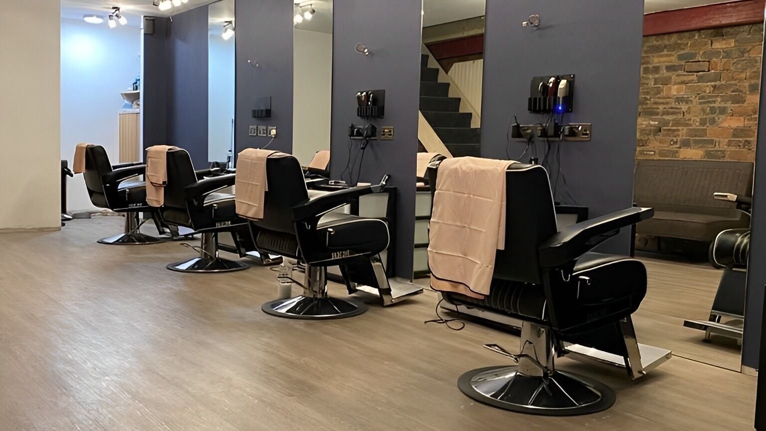 Modern barber chairs at Scott’s Barbers in Clarkston, Scotland, GB, showcasing a sleek and inviting interior.