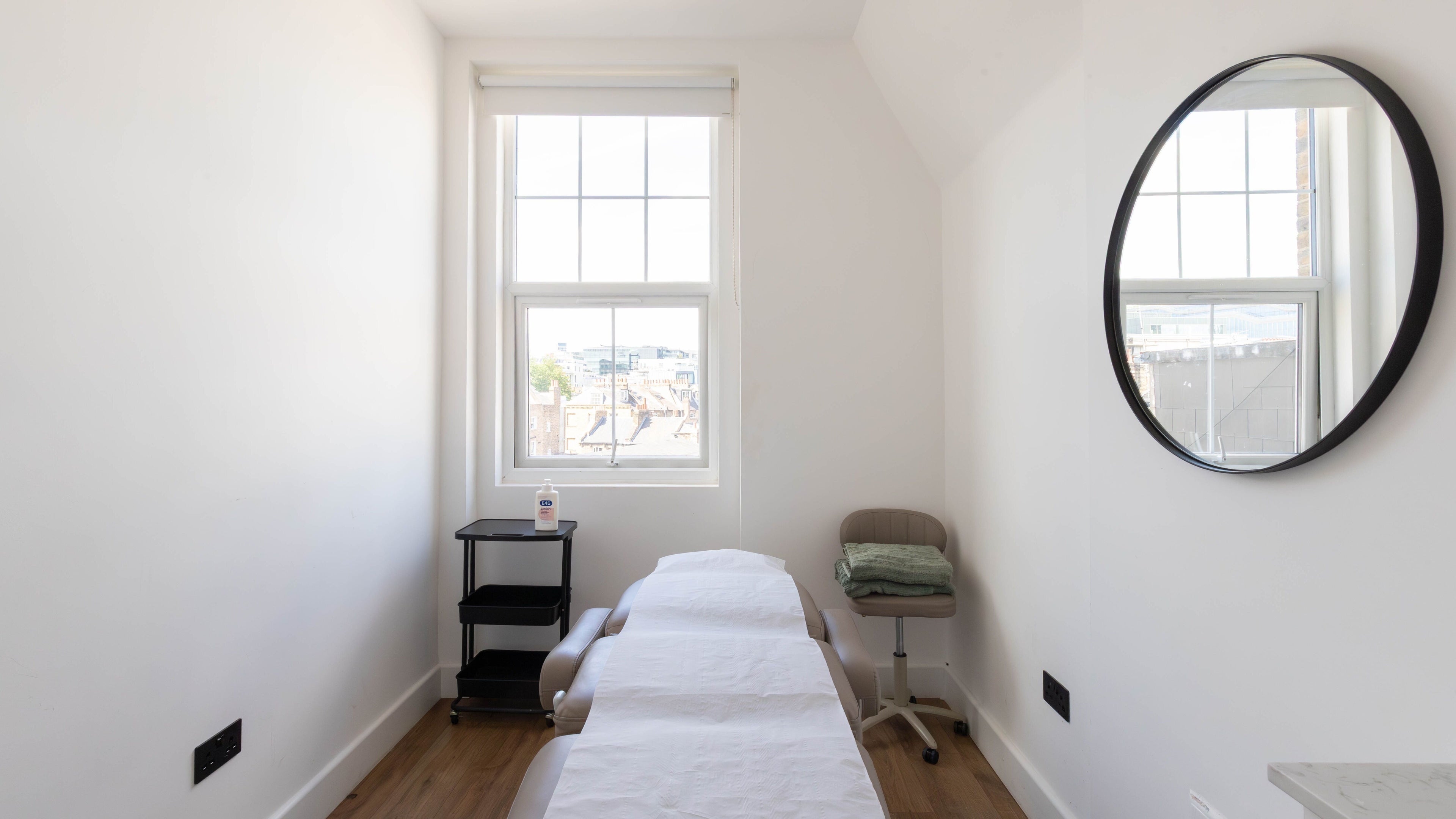 Well-lit treatment room at Achilles Clinic in London, England, GB, featuring a massage table and soothing decor.