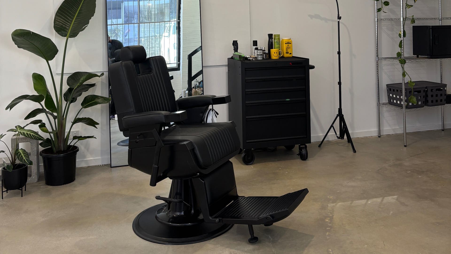 Sleek barber chair and greenery at Flows, South Brisbane, Queensland, AU, embodying modern elegance.