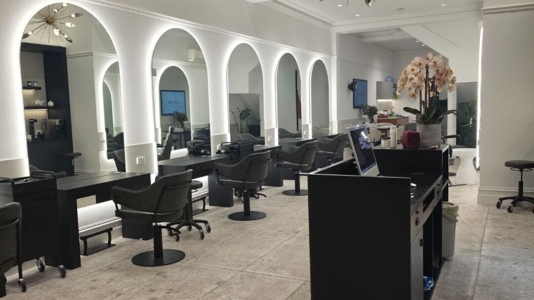 Chic salon interior at Madu's Creation, Melbourne, Victoria, AU with arched mirrors and stylish seating.