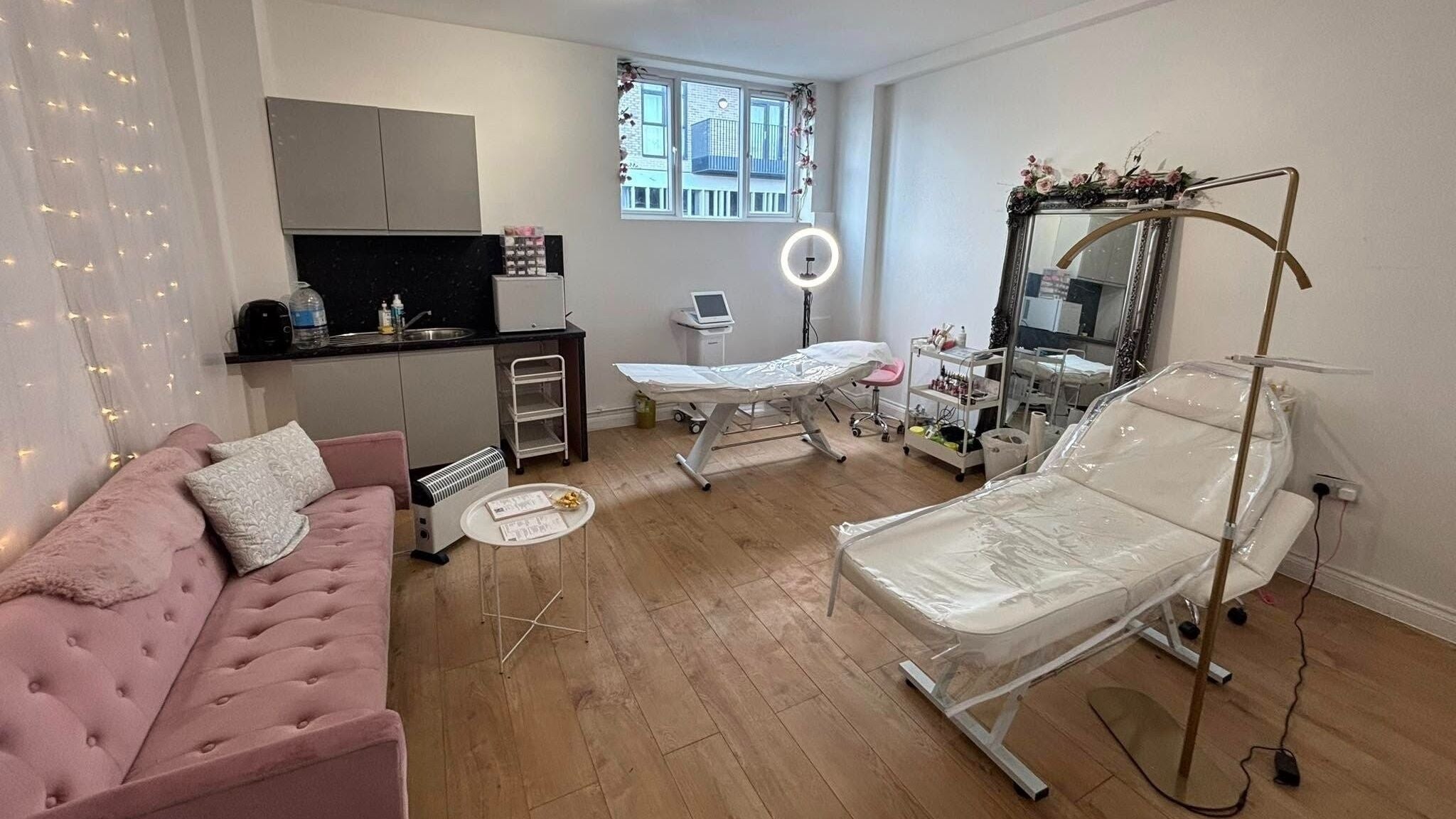 Cozy treatment room at Mia Bella - Wilmslow, Wilmslow, England, GB with pink couch and beauty equipment.