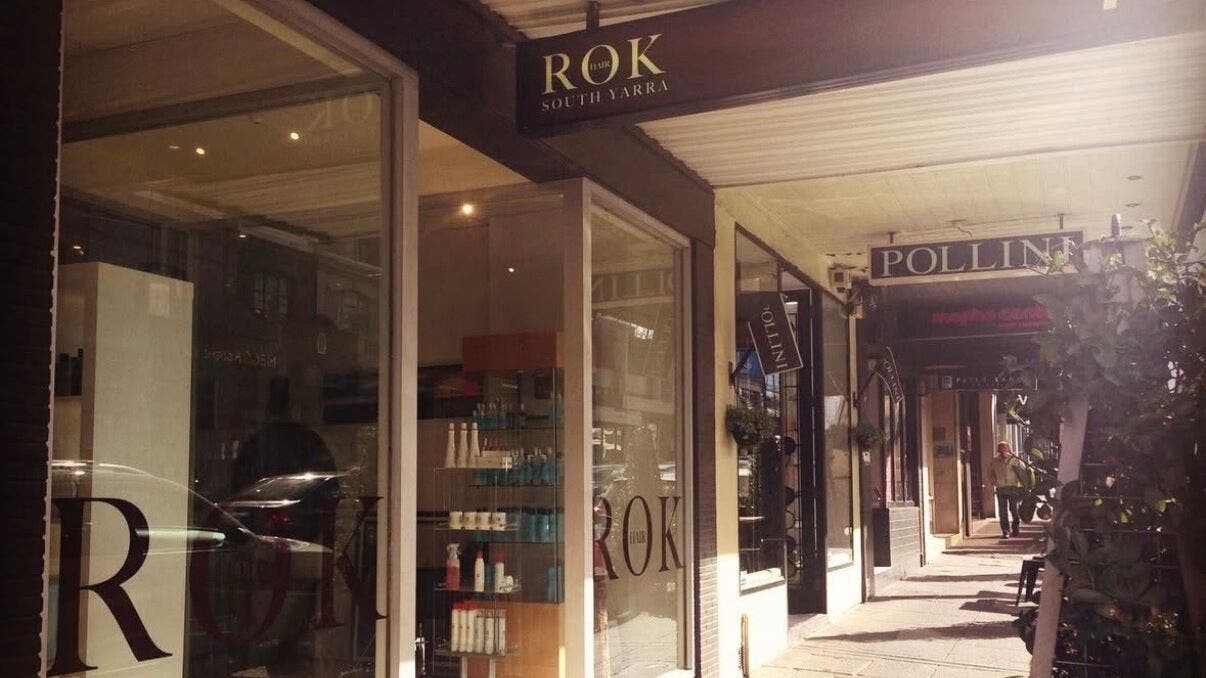 Exterior view of Rok Hair salon, Melbourne, Victoria, AU showcasing sleek glass windows and signage.