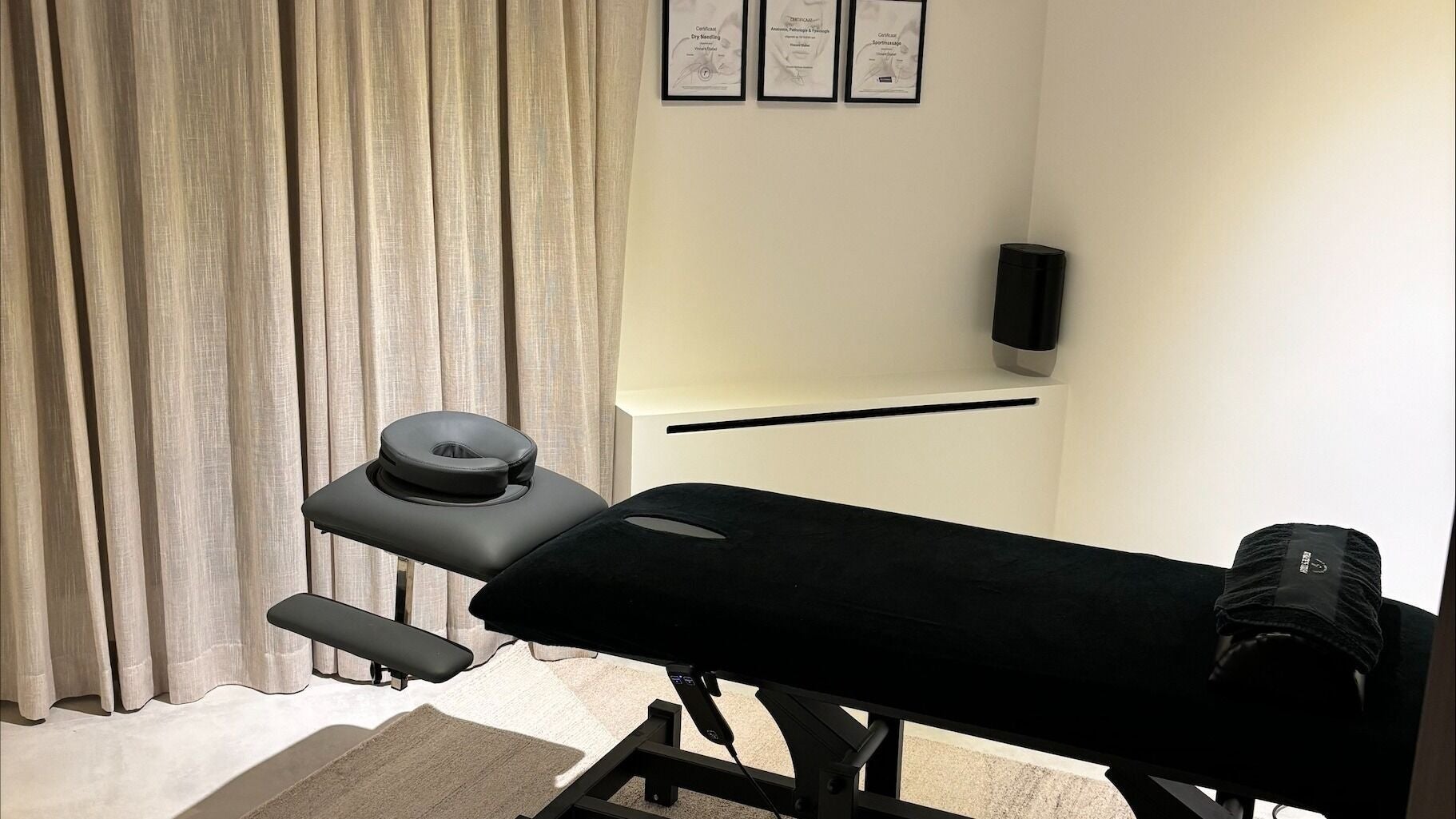 Moderne behandelkamer bij Athlete's Touch, Lier, Vlaanderen, BE met massagetafel en diploma's.