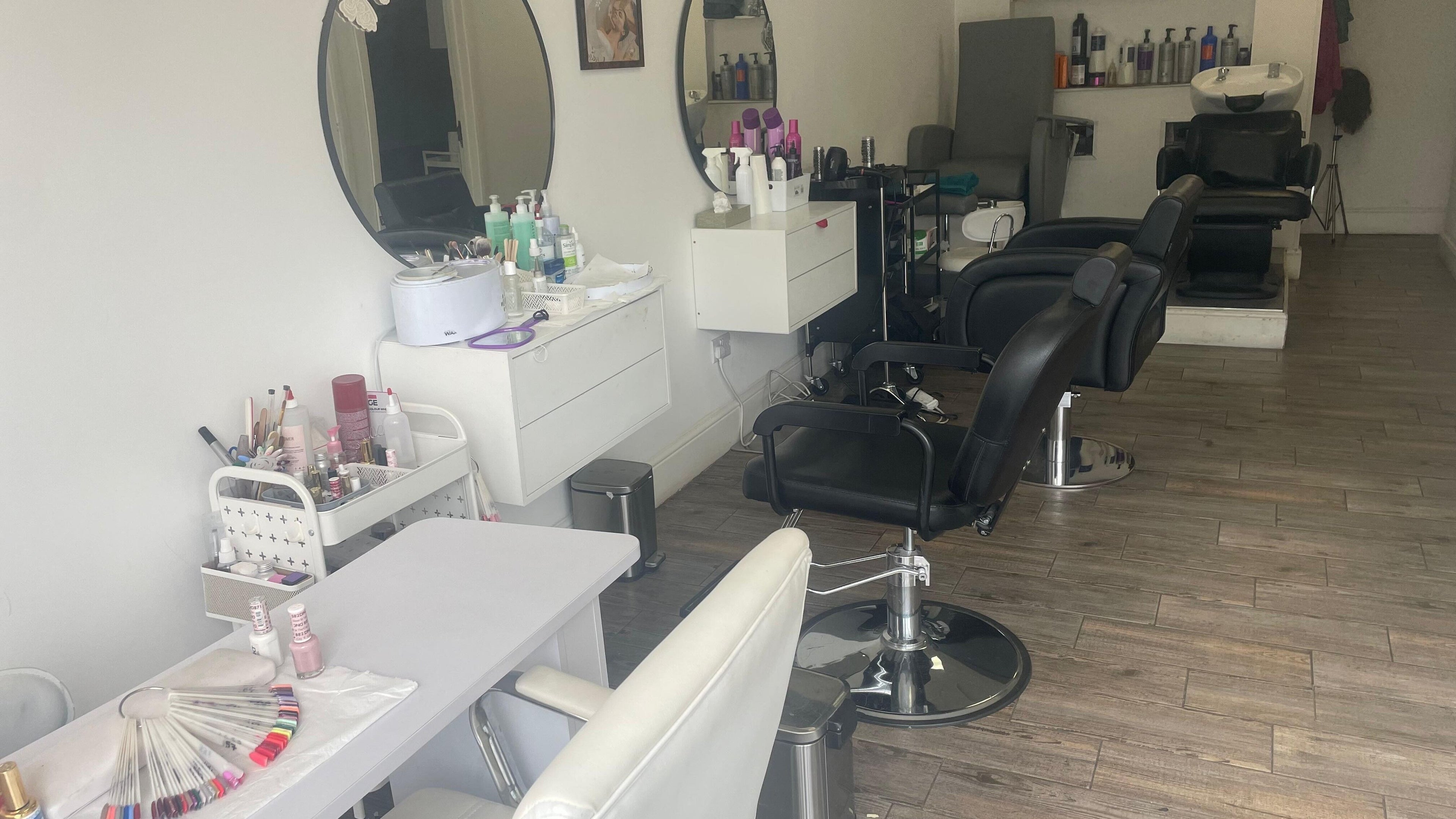 Modern salon setup at Strands Salon, Staines-upon-thames, England, GB, showcasing stylish chairs and beauty products.