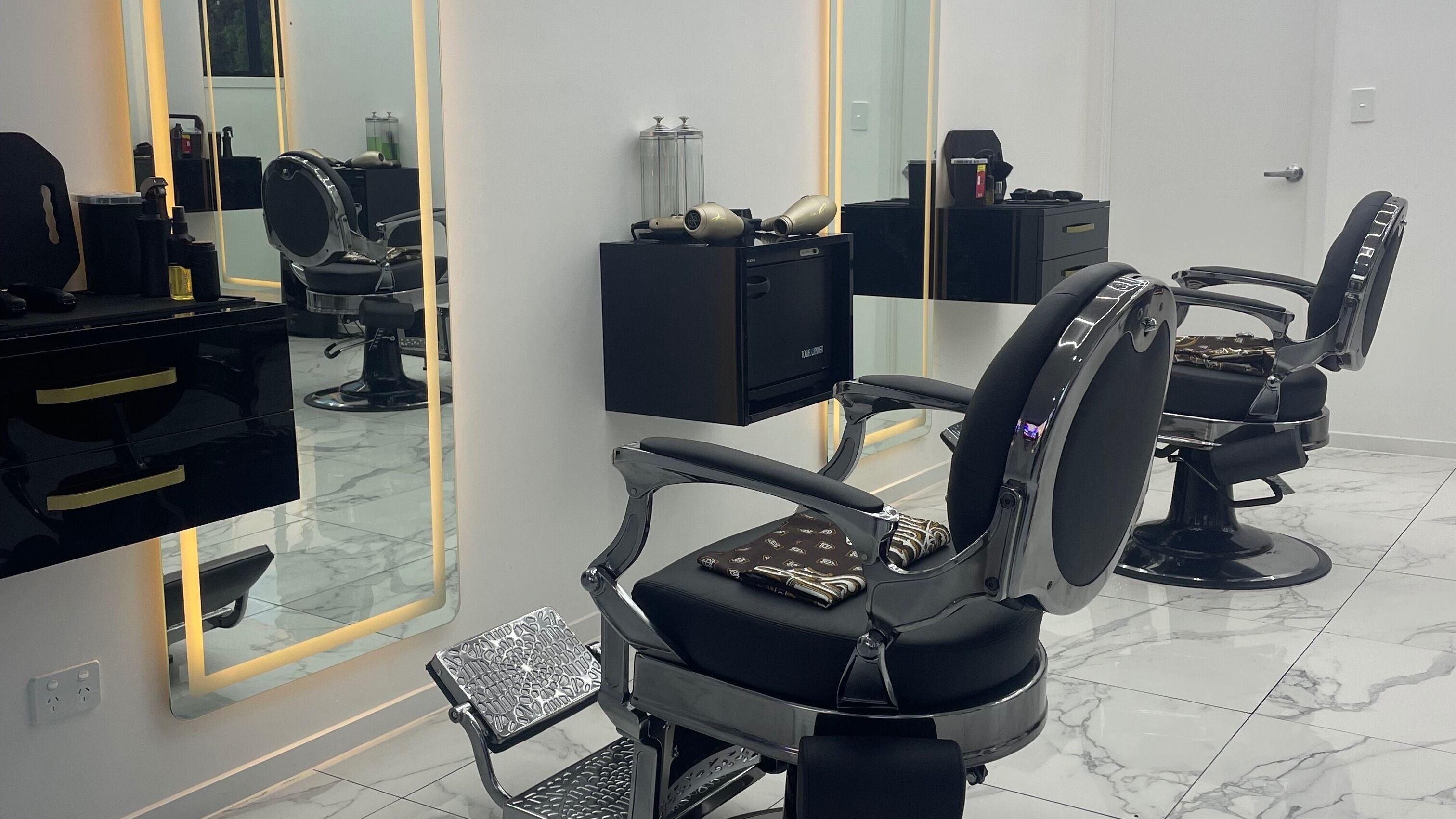 Elegant, modern barber chairs at Crwn Barbers in Auckland, Auckland, NZ with stylish decor and lighting.