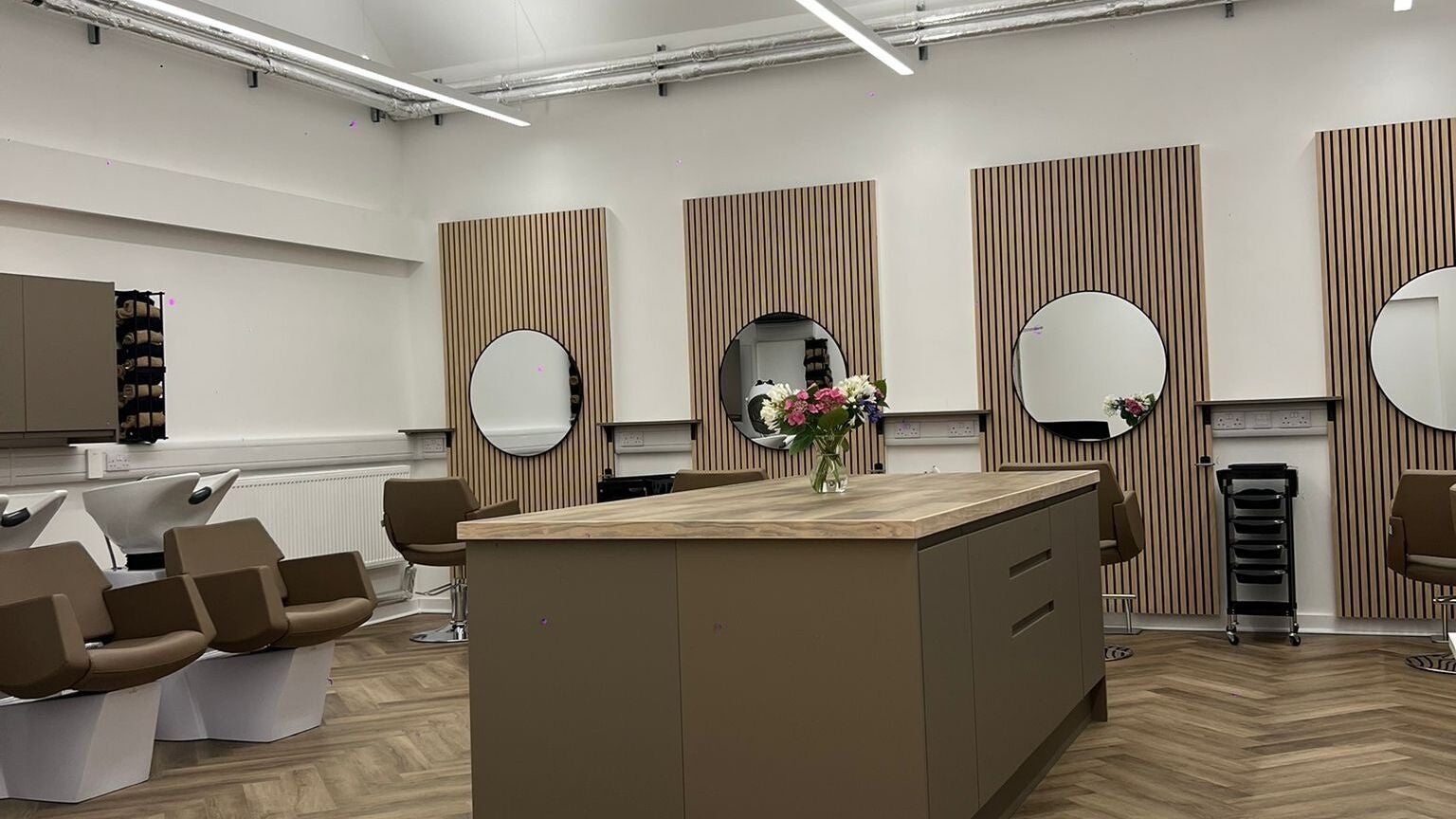 Modern salon interior at Envi Southwold, Southwold, England, GB, showcasing mirrors and styling chairs.