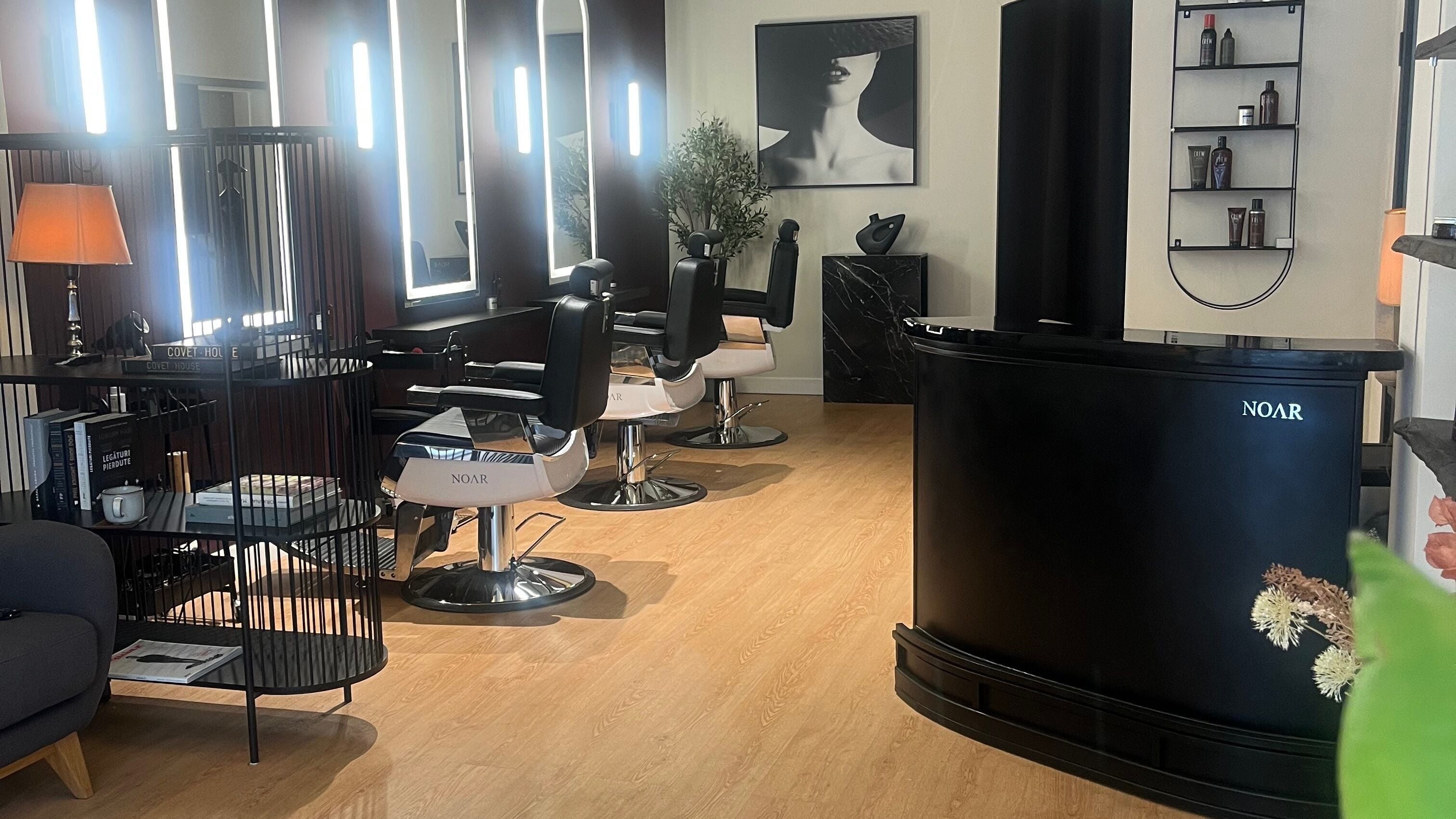 Interior acogedor de Noar Barberia Boutique en Barcelona, Cataluña, ES con sillas modernas y decoración elegante.