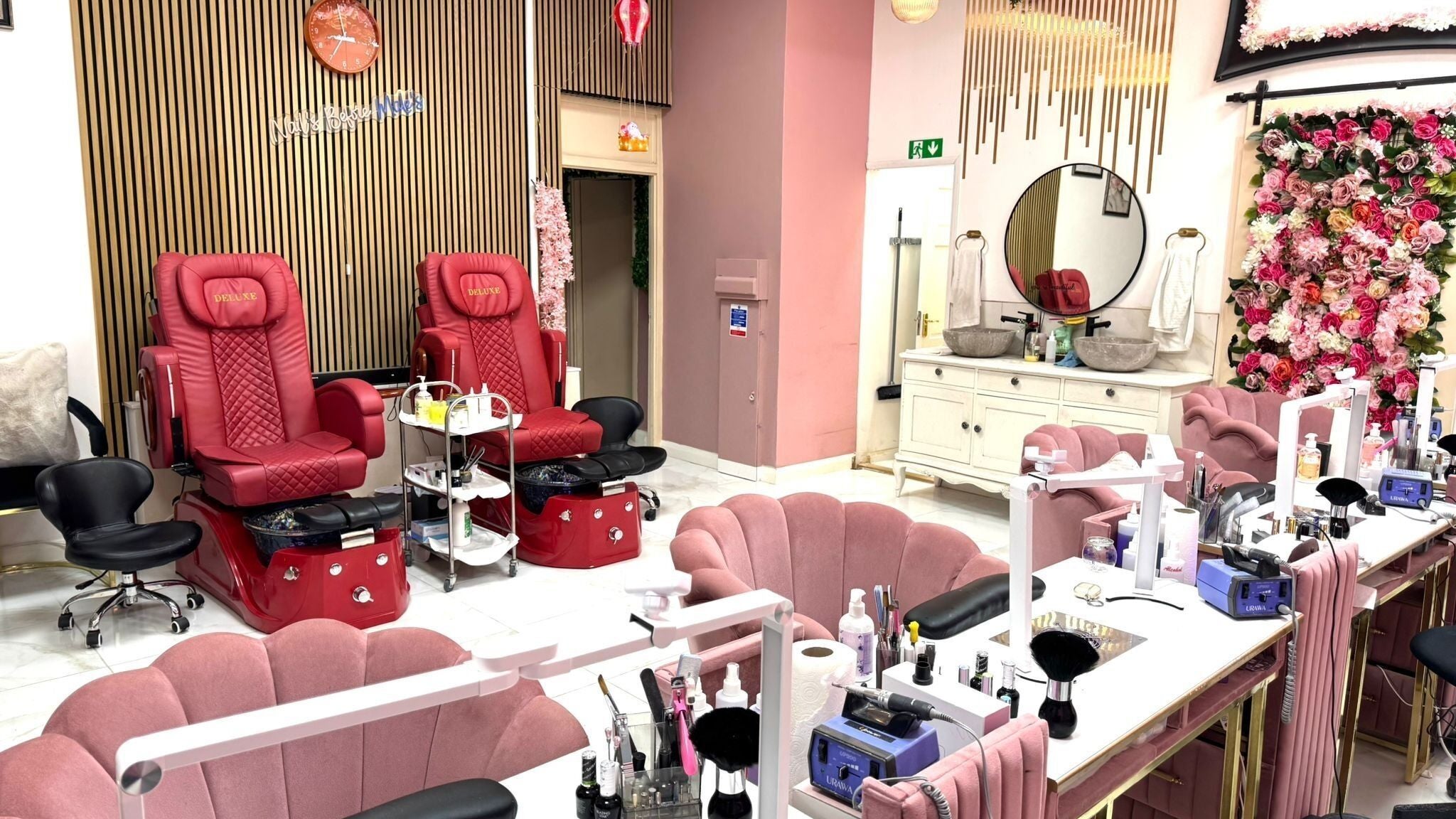 Elegant interior of Nikki D Nails Beauty Aesthetics in Chadwell St Mary, England with plush seating and floral decor.