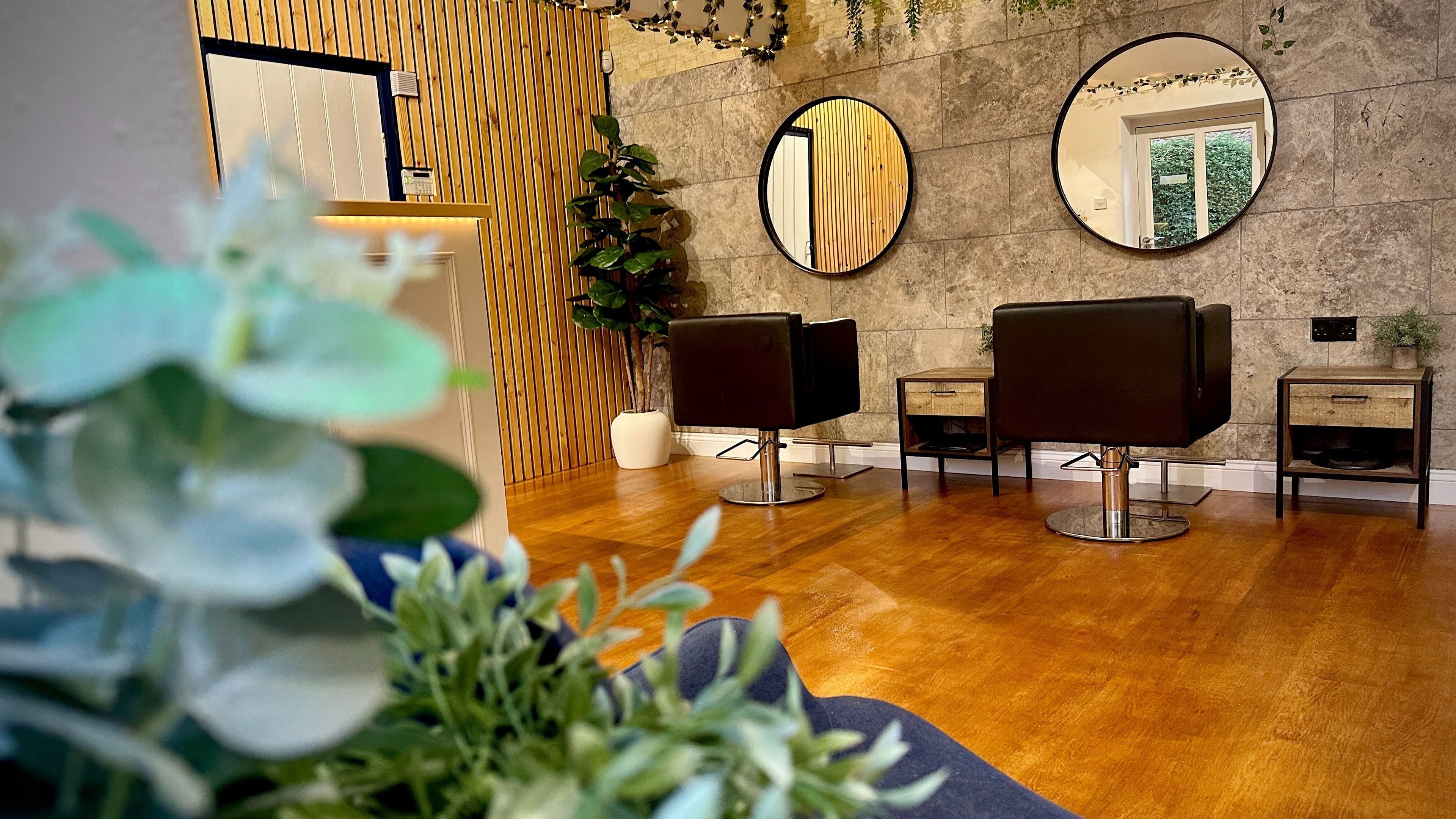 Elegant seating area with mirrors at Apple Hair Design, Holt, England, GB, showcasing modern décor.