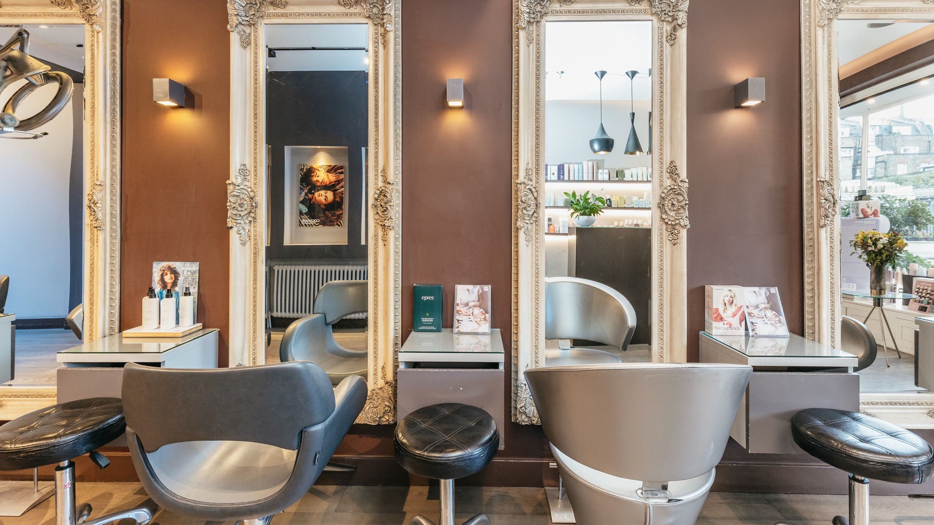 Elegant salon interior at Decadence Hair and Beauty, London, England, GB, showcasing chic styling stations and mirrors.