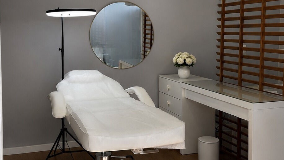Sala de tratamentos Andréa Beauty, Lisboa, PT. Cadeira de estética branca com decoração moderna.