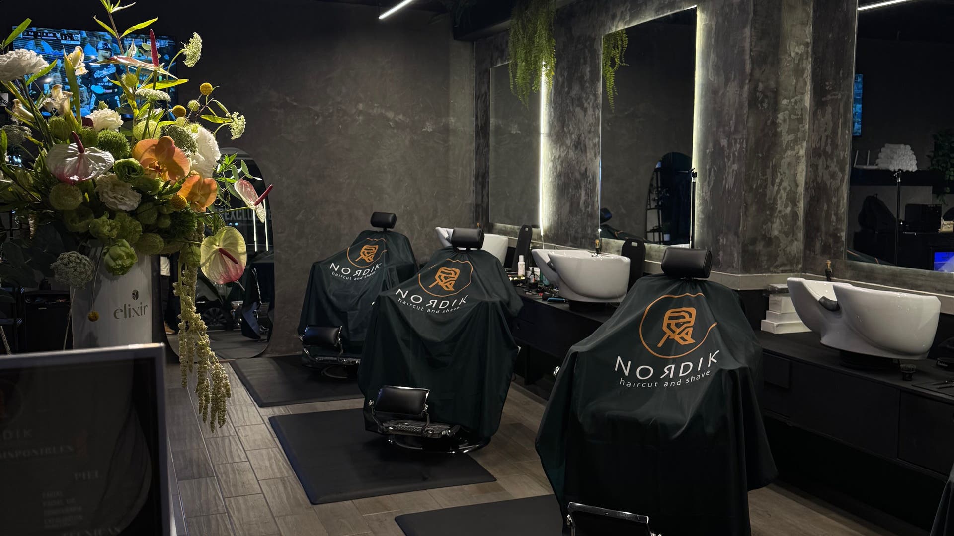 Interior moderno de Nordik Del Valle en Ciudad De México, MX con sillas de barbero y arreglo floral.