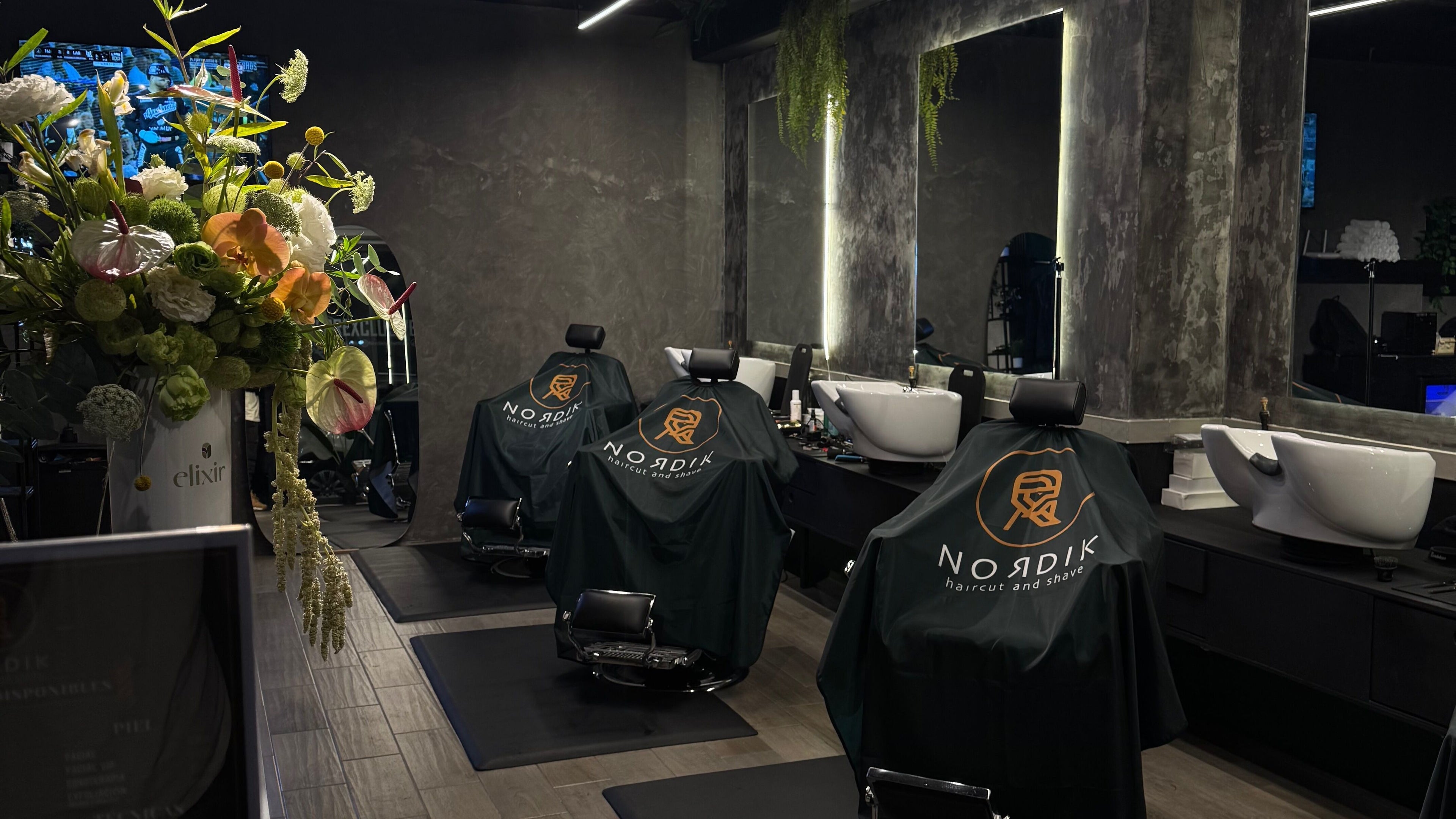 Interior moderno de Nordik Del Valle en Ciudad De México, MX con sillas de barbero y arreglo floral.