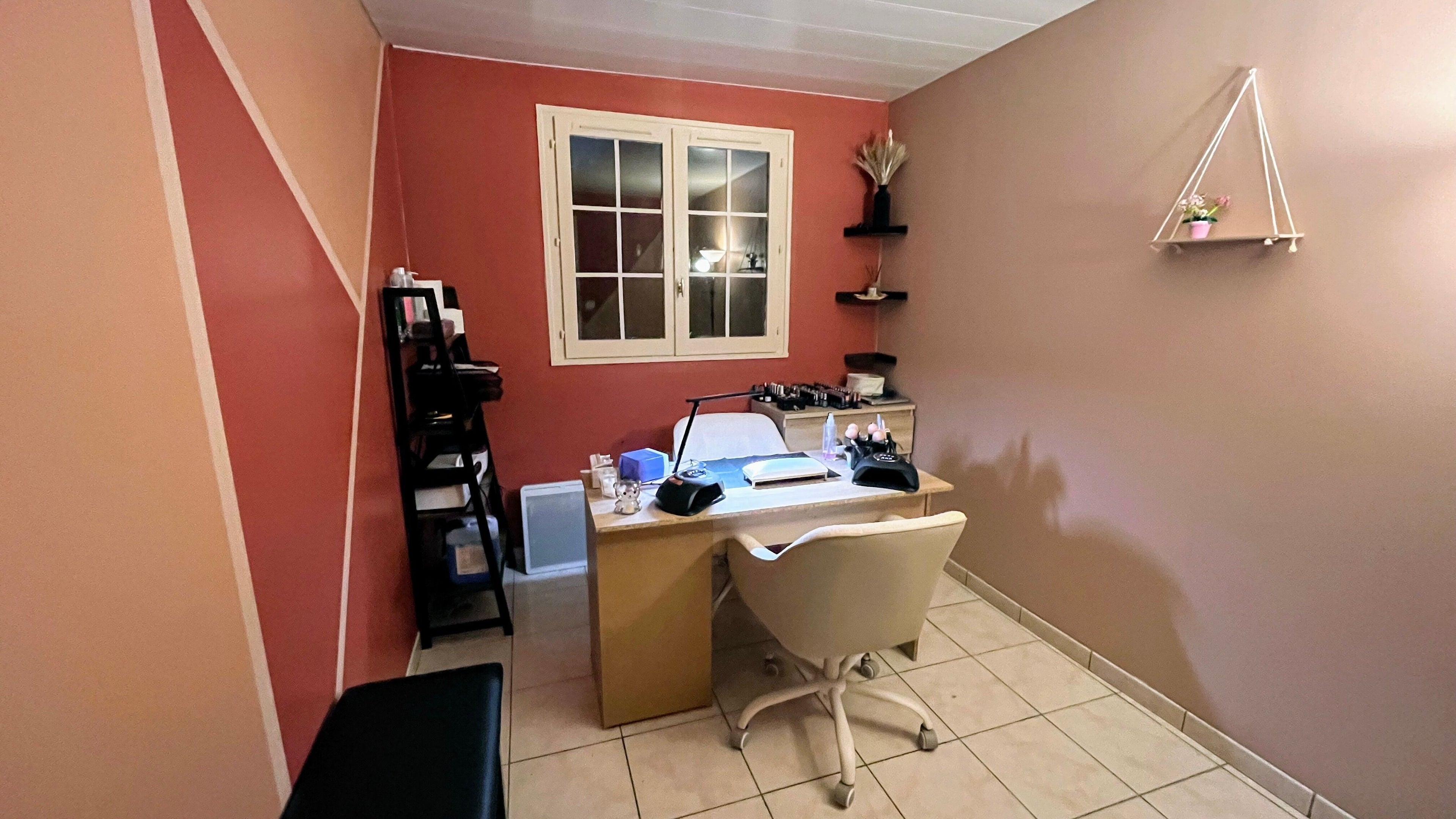 Salon de manucure élégant chez DivineNails à Chelles, Île-de-france, FR, avec mur corail et poste de travail.