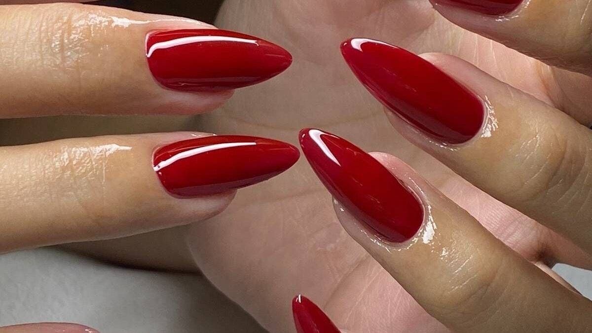 Elegant red manicure at Nailcita Bysim in London, England, GB showcasing glossy nail art.