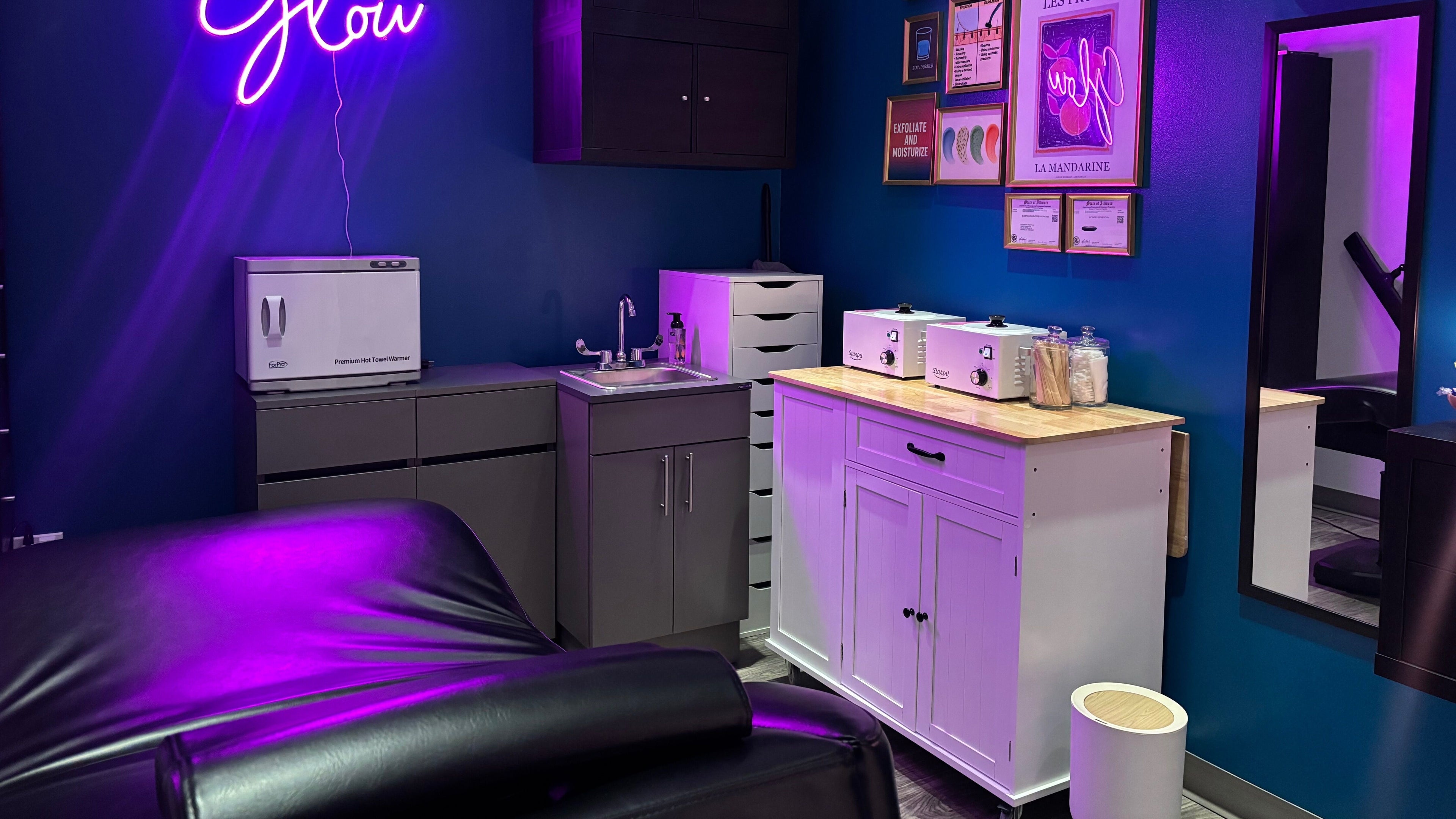 Modern beauty treatment room at Glow With Lindsay in Chicago, Illinois, US with elegant purple lighting.