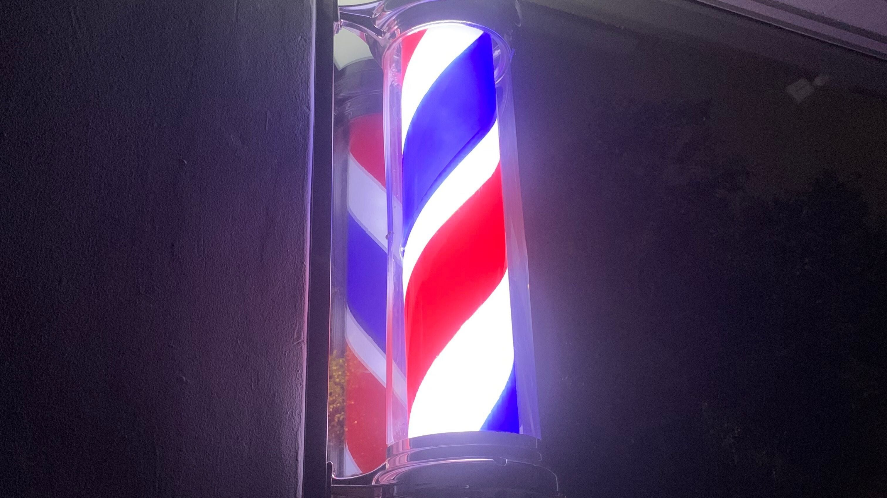 Illuminated barber pole at night outside EXODUS BLENDS, Umhlanga, Kwazulu-natal, ZA.