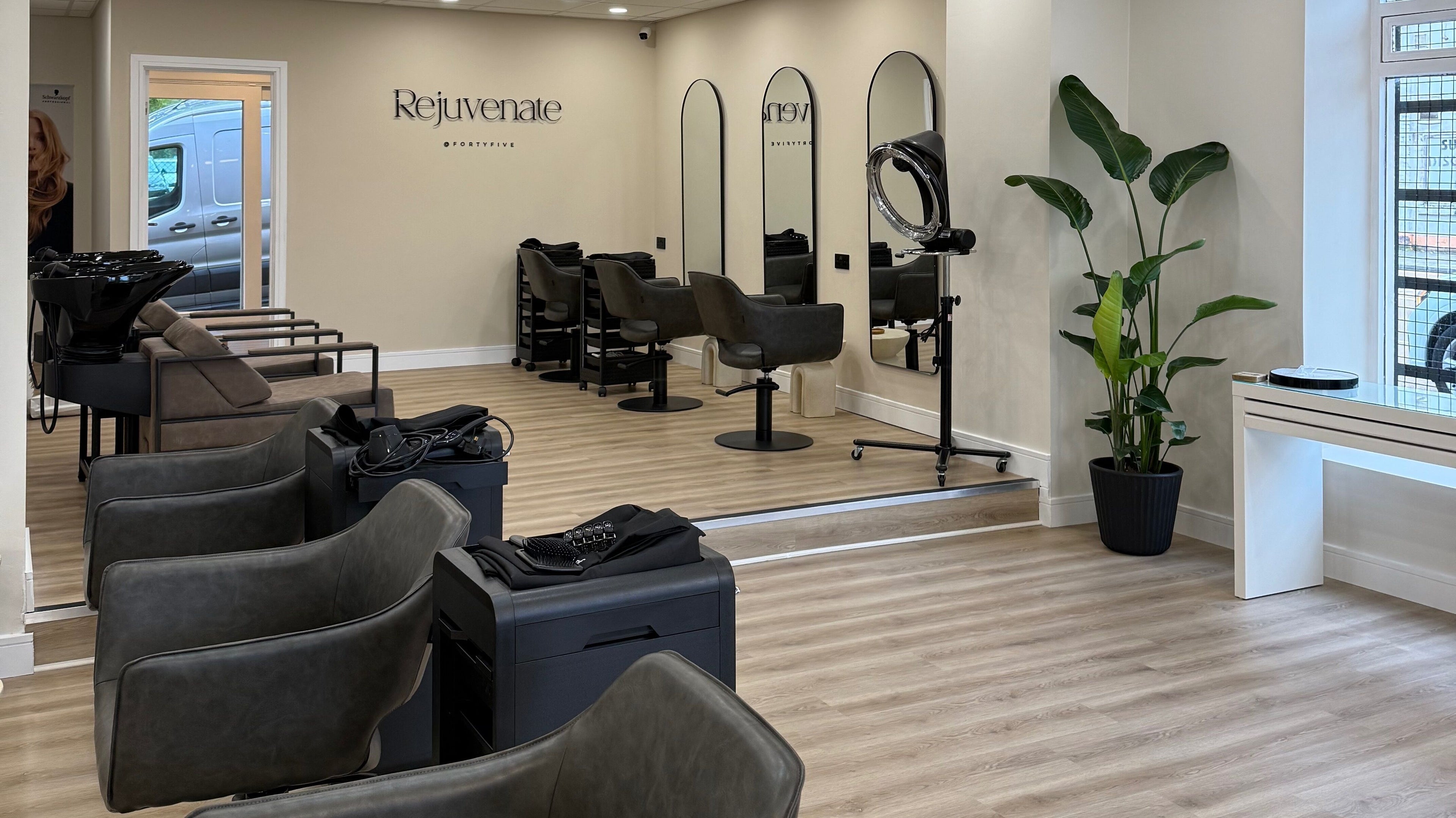 Modern salon interior at Rejuvenate@45, Stockport, England, GB featuring sleek styling chairs and mirrors.
