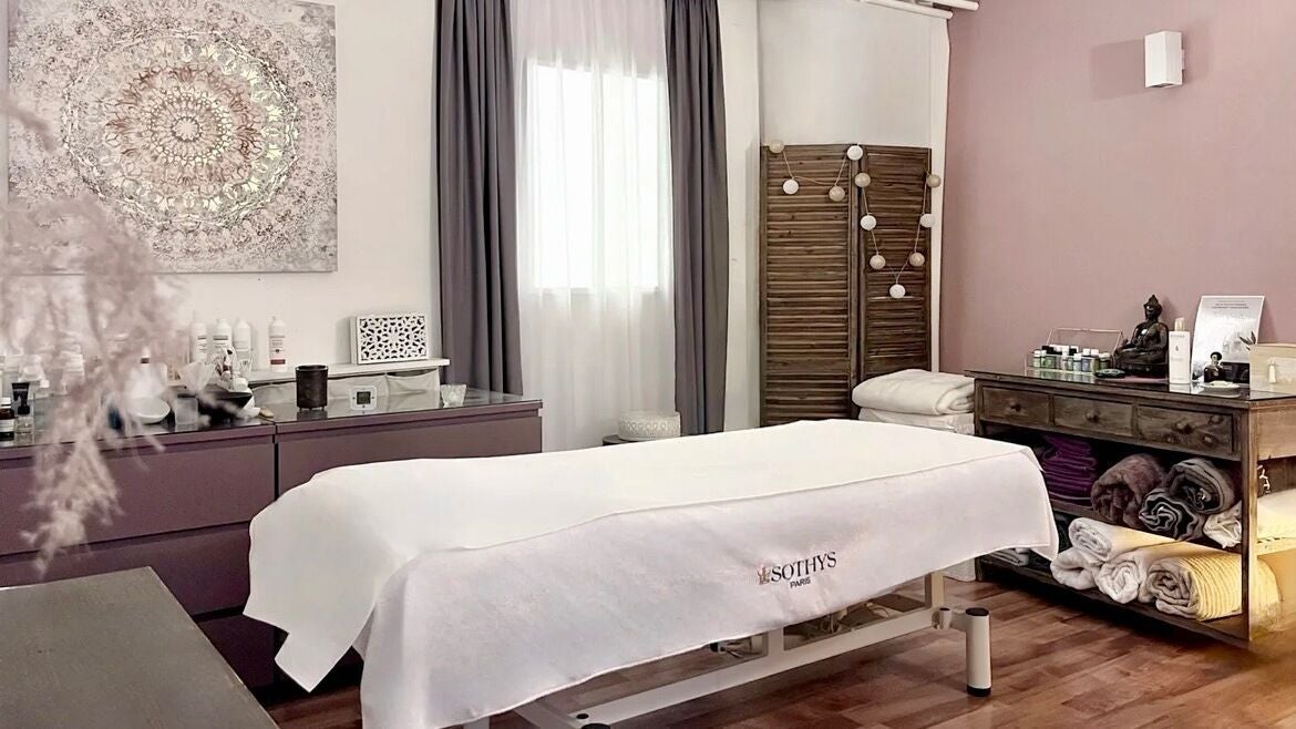 Salle de soins relaxante à Espace des Sens - Marie Meylan, Lausanne, Vaud, CH, avec table de massage et décor apaisant.