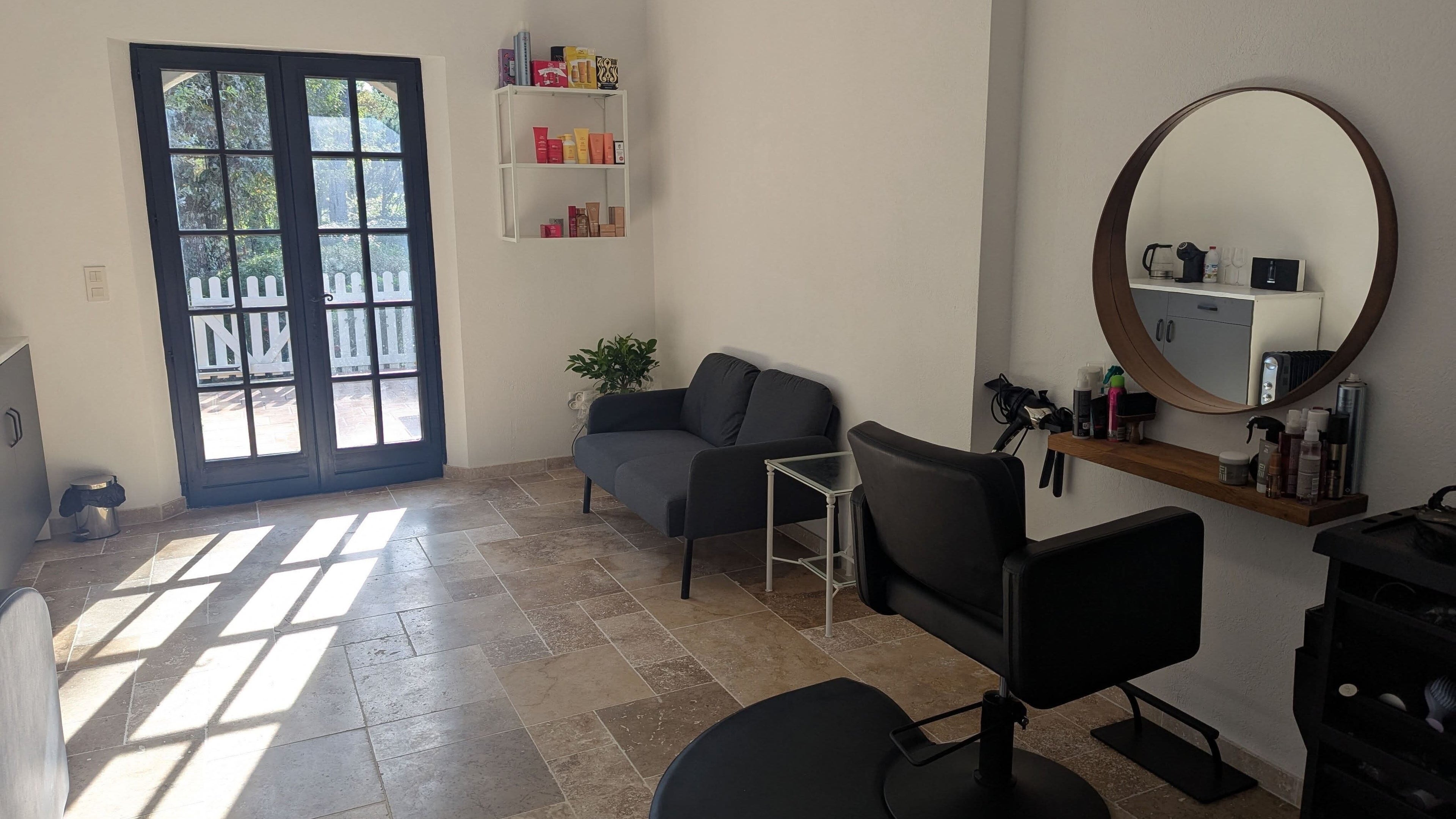 Chez Lucy English Hairdresser in Fayence offers a cozy, sunlit salon with modern decor and professional styling area.