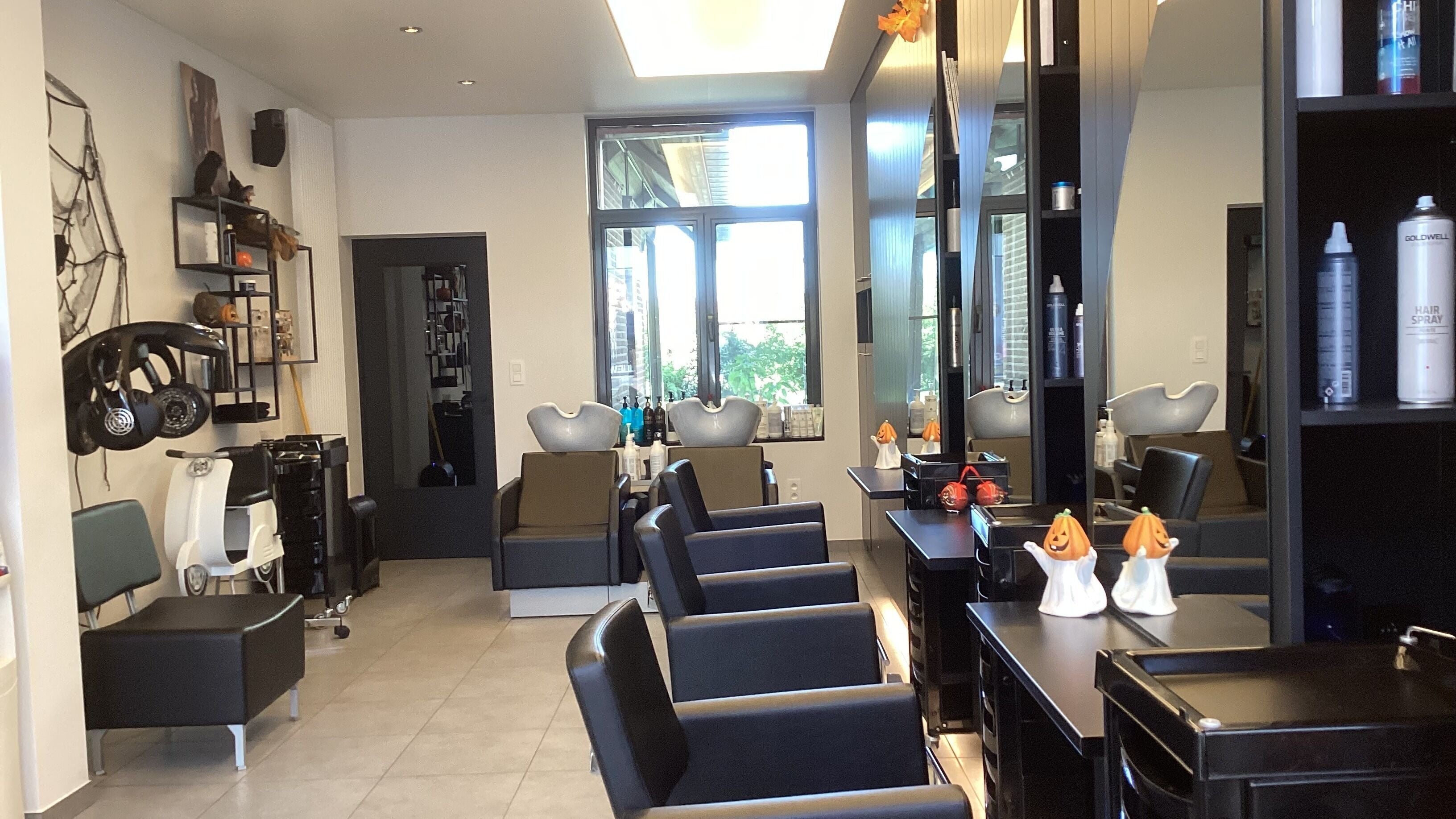 Interieur van Kapsalon Sigrid in Waregem, Vlaanderen, BE met moderne kappersstoelen en spiegels.