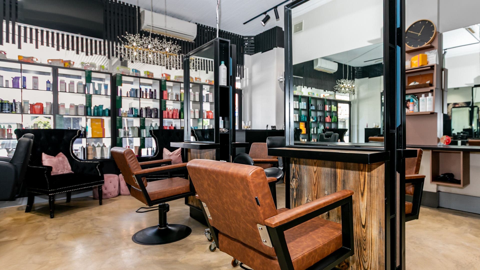 Interior view of Lotus Hair Salon in Camberwell, Victoria, featuring stylish chairs and product shelves.