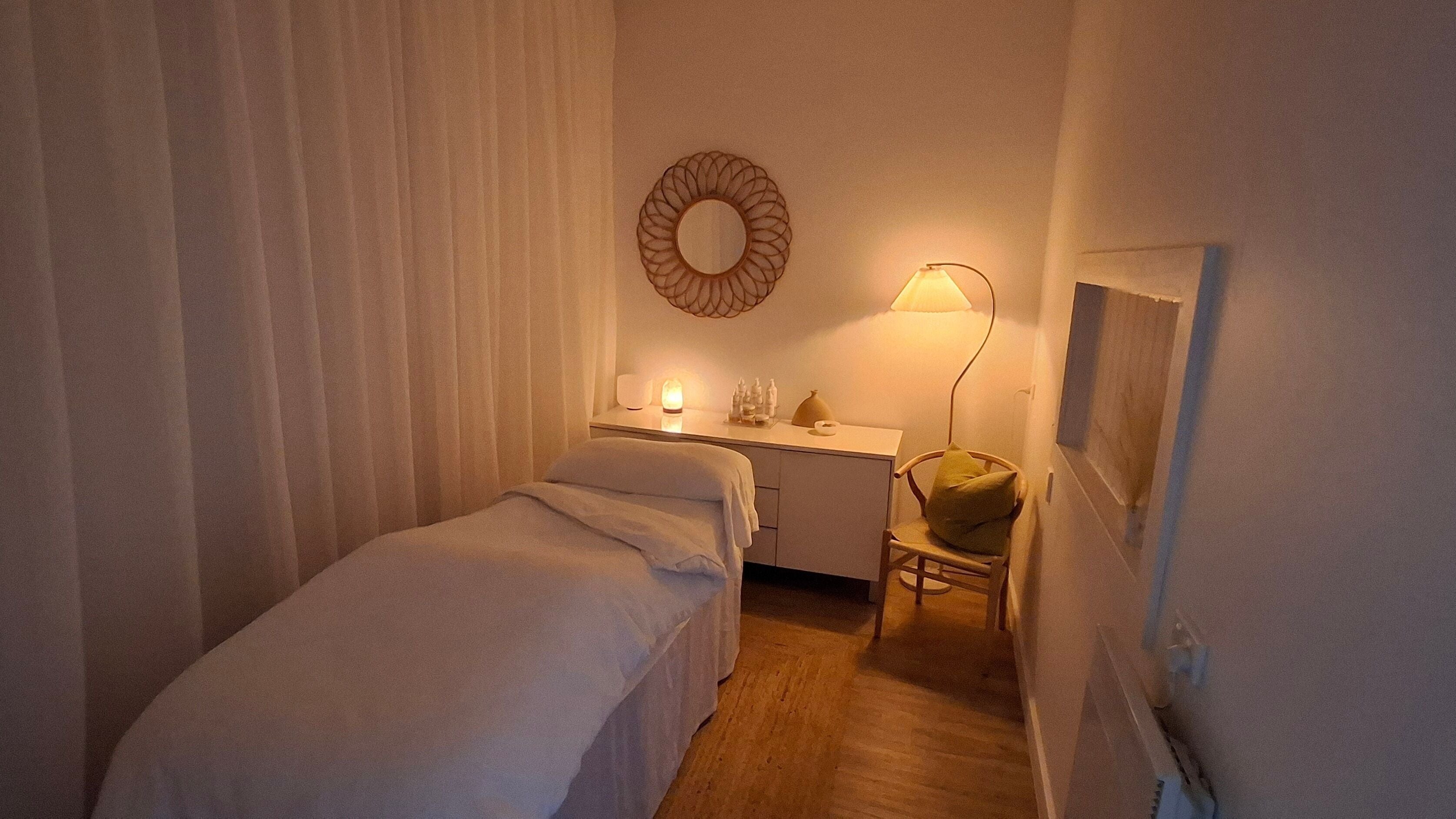 Peaceful massage room at Calma Studio, Melbourne, Victoria, AU, with warm lighting and soothing décor.