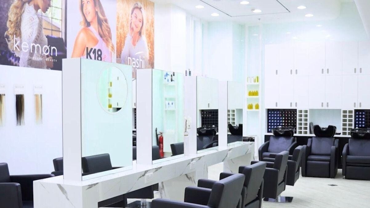 Contemporary salon interior at Hair Colosseum Beauty Salon, Dubai, AE, featuring sleek styling chairs and mirrors.