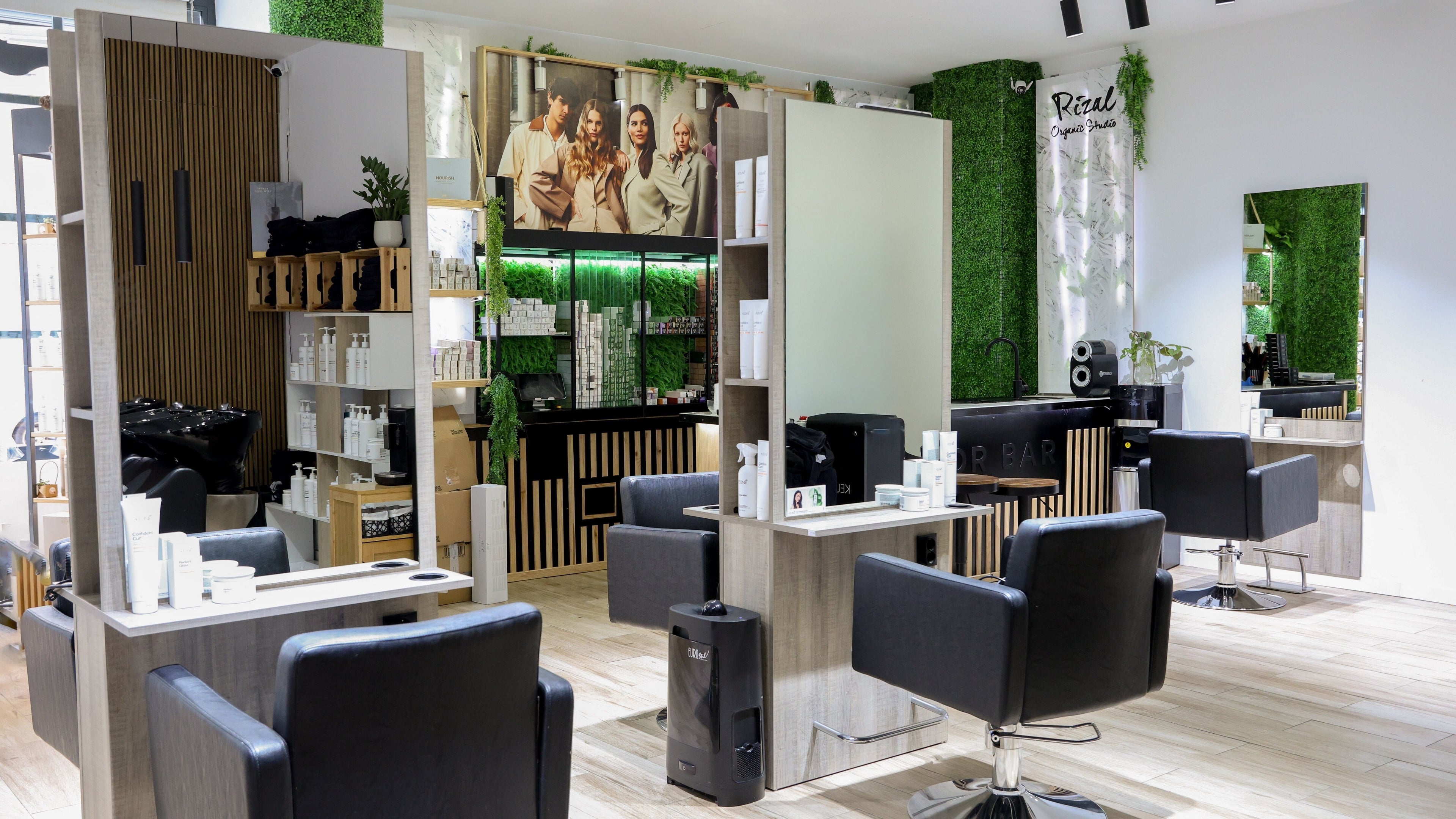 Salón moderno y elegante en Rizal Organic Studio, Madrid, Comunidad De Madrid, ES, con sillas negras y vegetación.