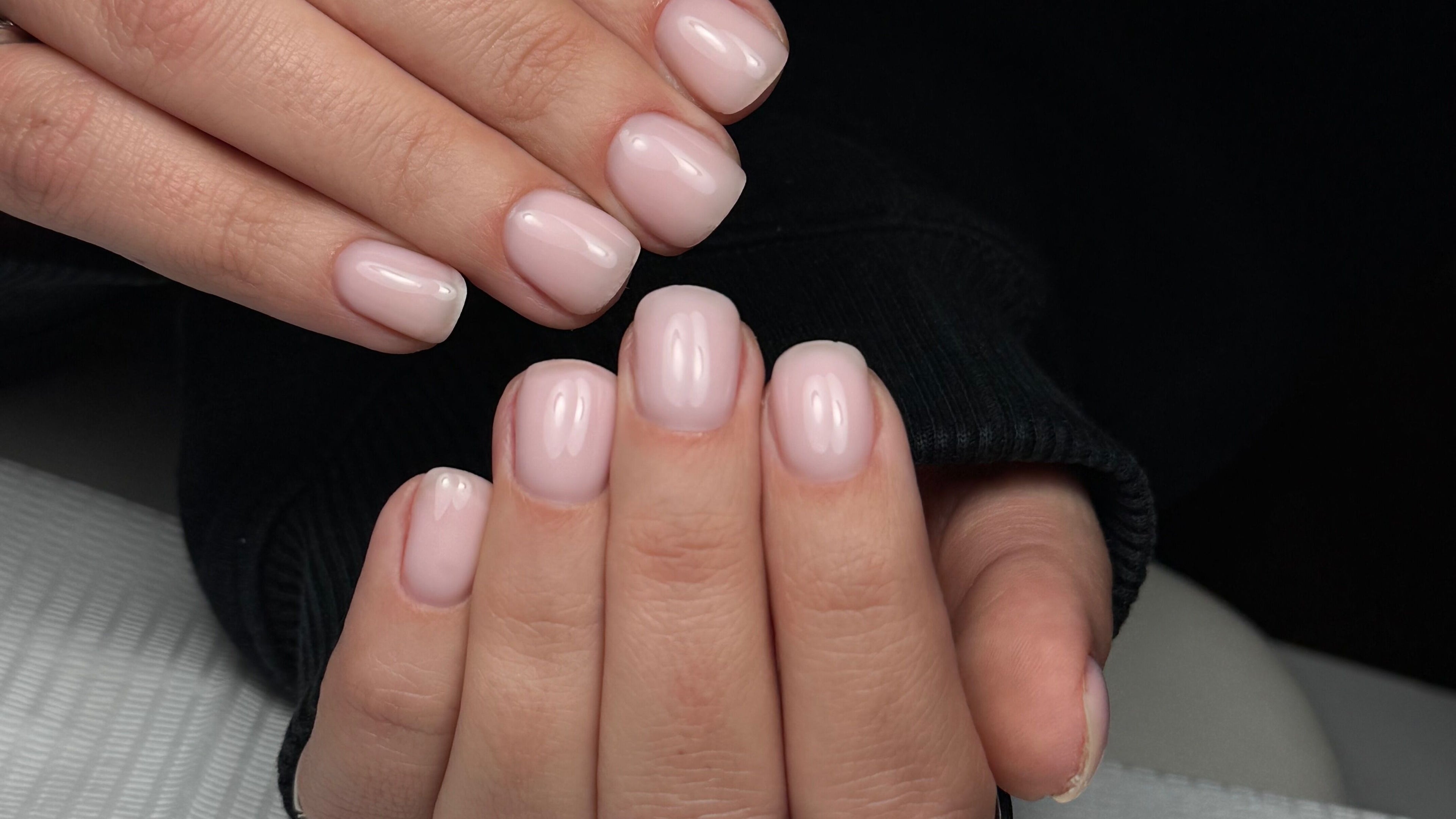 Close-up of manicured nails with soft pink polish at Mia Beauty, San Jose, California, US.
