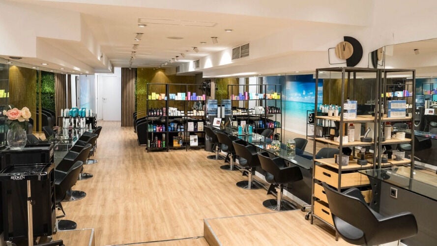 Interior moderno de Le Petit Salon en Barcelona, Catalunya, ES, con sillas negras y productos de belleza.