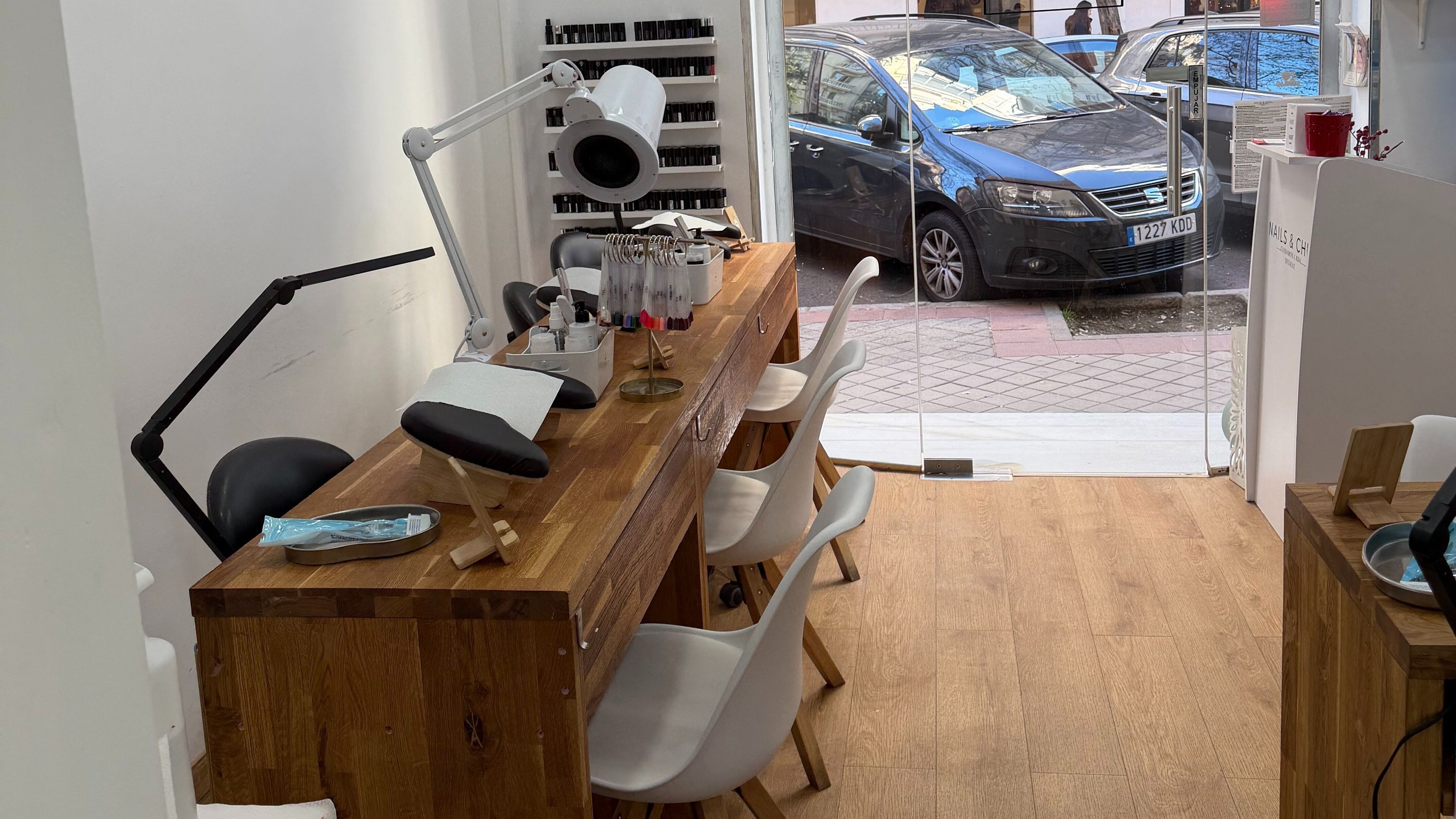 Mesa de manicura en Nails & Chill, Madrid, Comunidad De Madrid, ES con sillas blancas modernas.