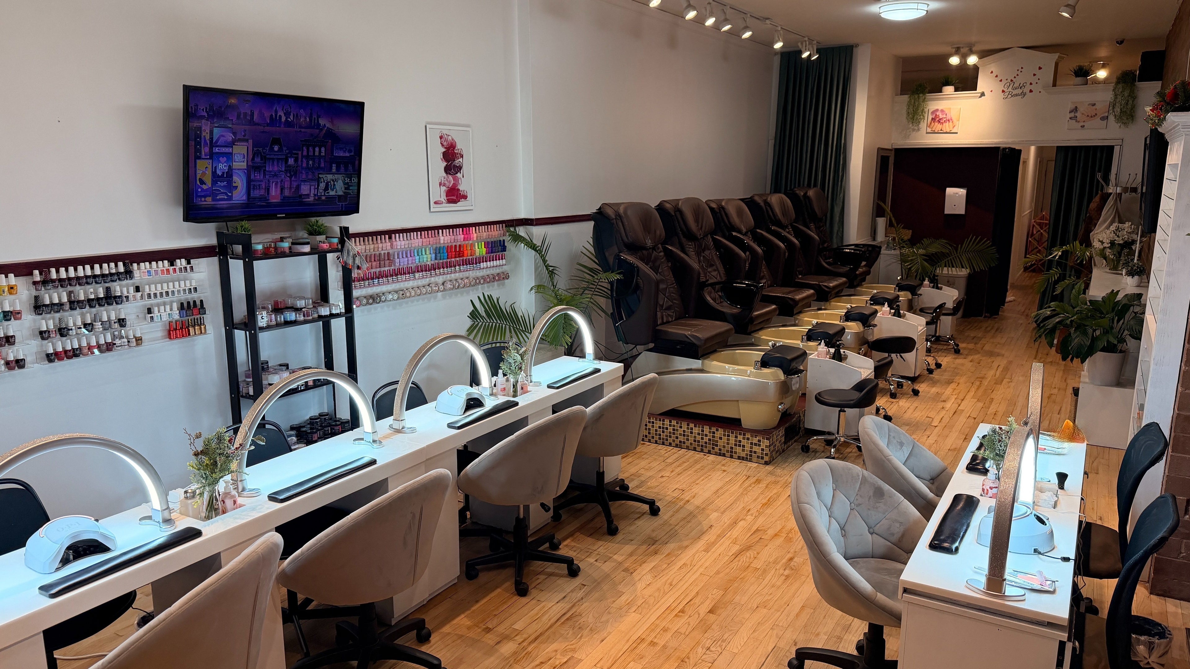 Modern nail salon interior at The Nail Bar on Division in Chicago, Illinois, US with plush seating and polish display.