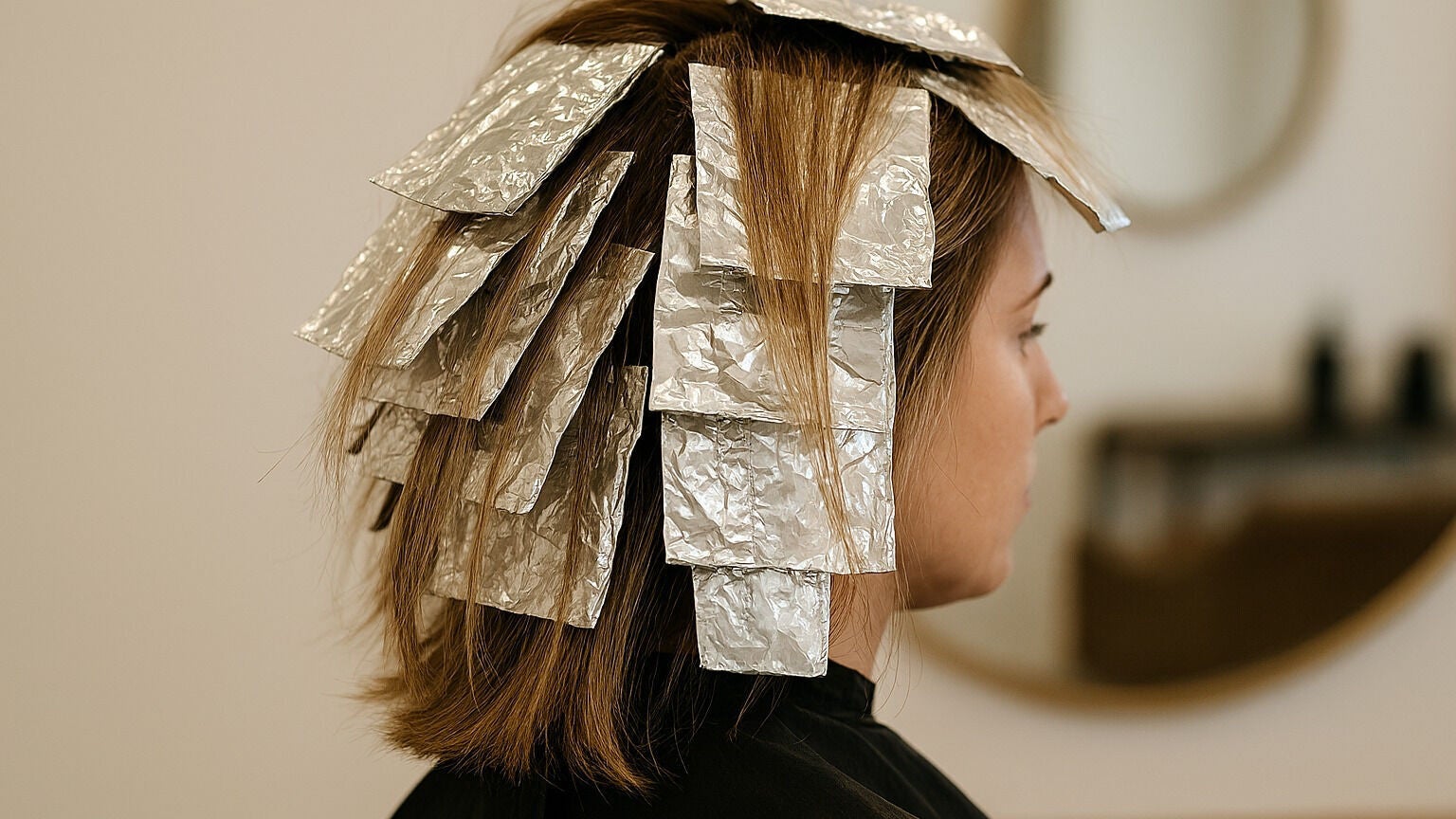 Hair highlighting process at Heavenly Hair Lounge, Laverton, Victoria, AU with foil wraps on brown hair.