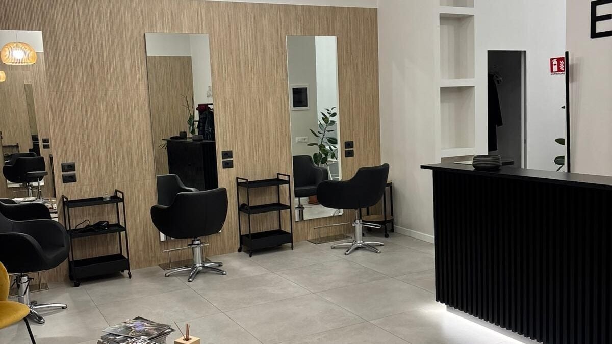 Interno moderno di Artehair Parrucchieri a Roma, Lazio, IT con specchi e poltrone eleganti.