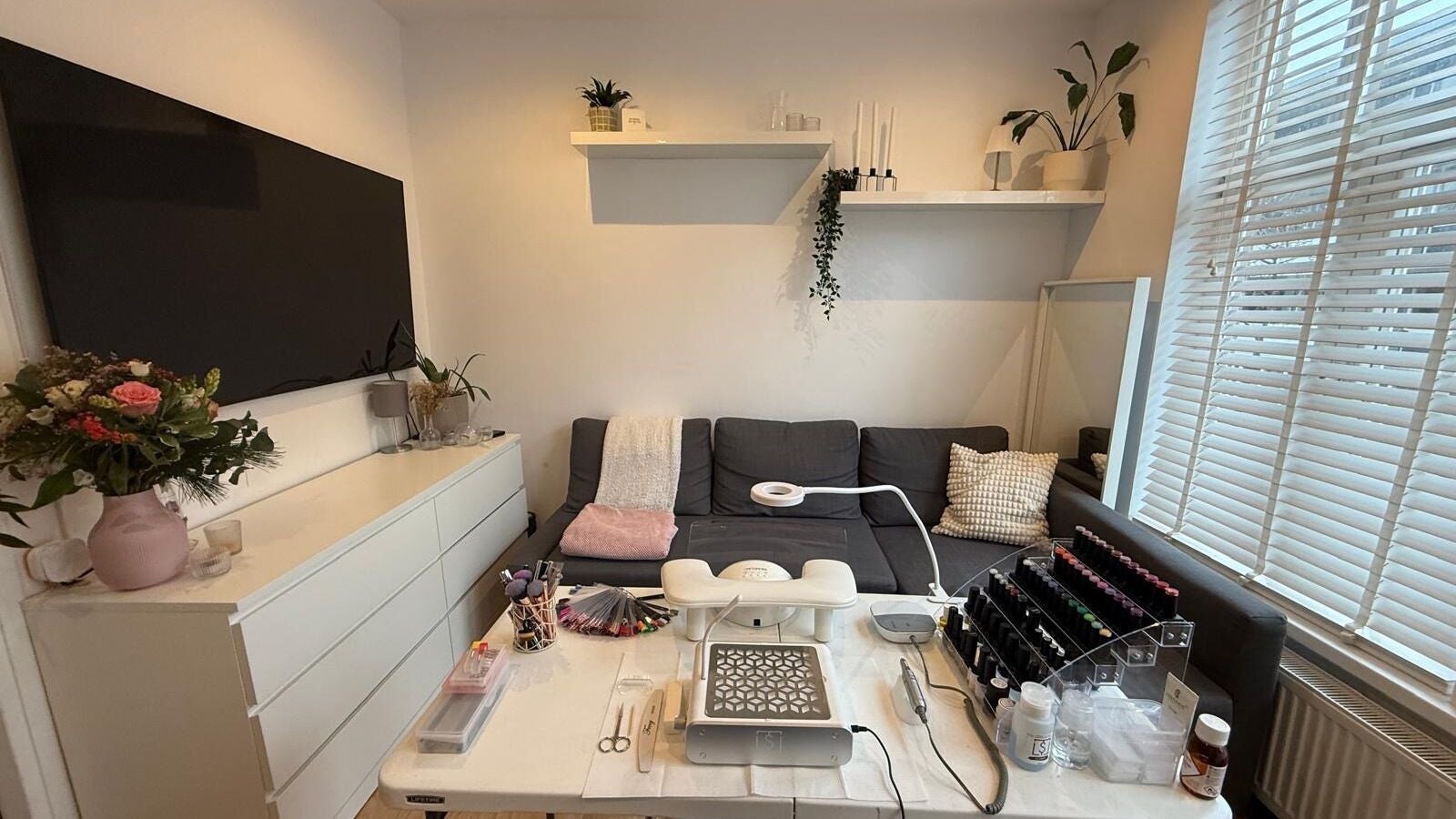 Gezellige salonruimte bij YOTAR.STUDIO, Amsterdam, Noord-Holland, NL met bank en nagelaccessoires.