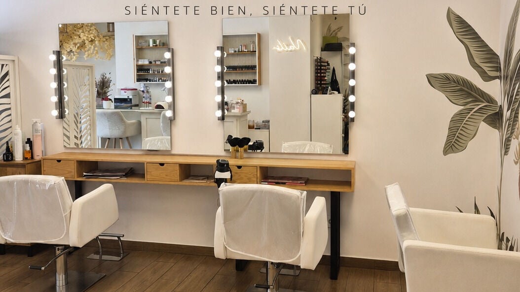 Interior de Flash belleza peluquería en València con espejos iluminados y sillas blancas cómodas.