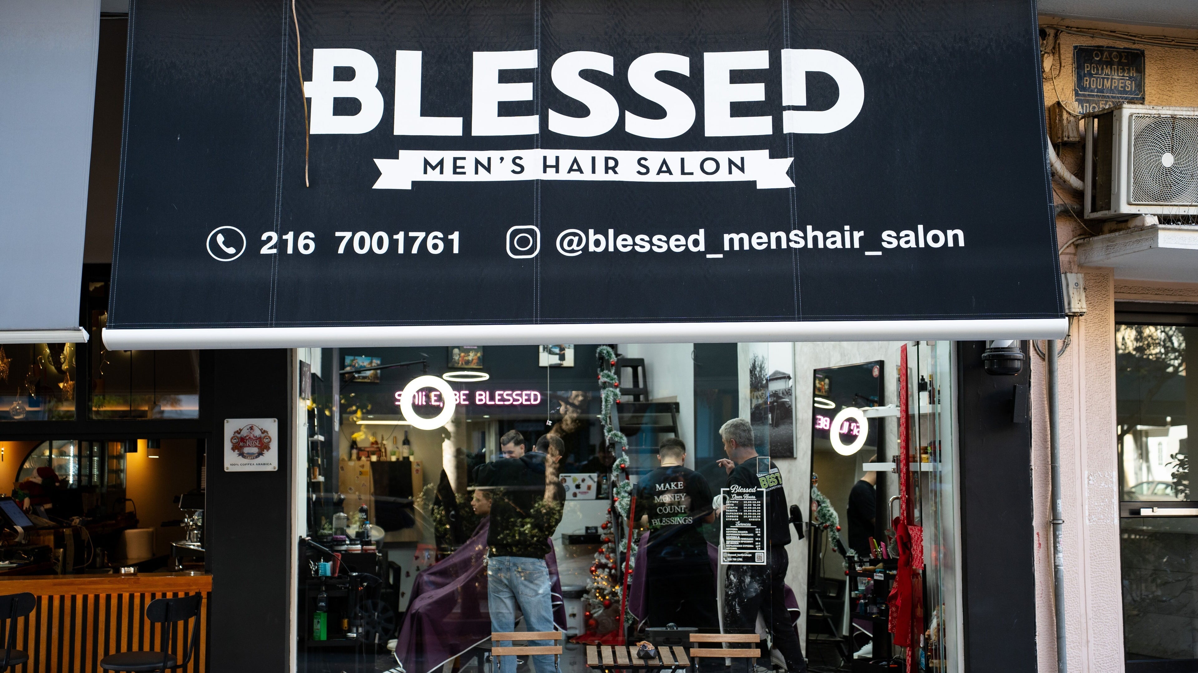 Πρόσοψη Blessed Barbershop Roumpesi 50 Neos Kosmos, Αθήνα, GR με κομψή πινακίδα και πολυάσχολο εσωτερικό.