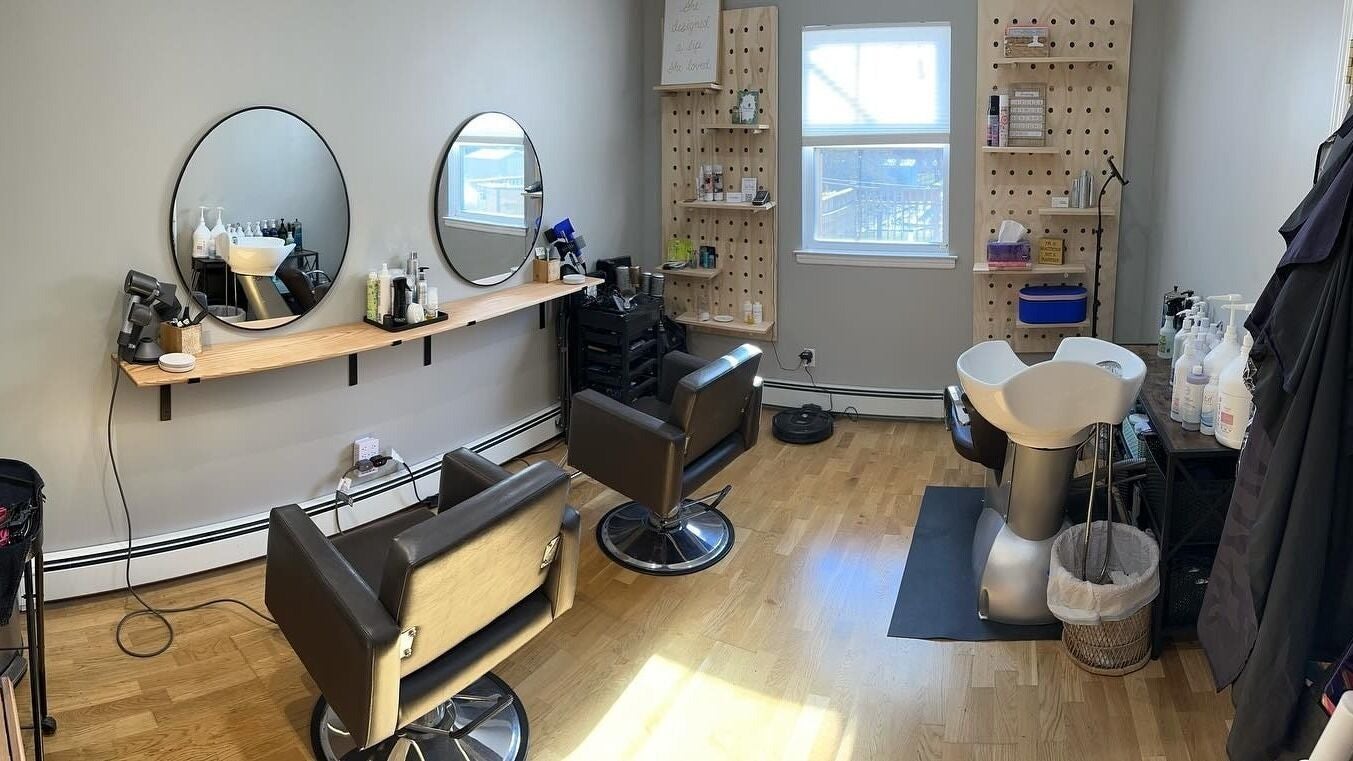 Modern salon interior at NME Hairstylist in Islip Terrace, New York, US, featuring styling chairs and mirrors.