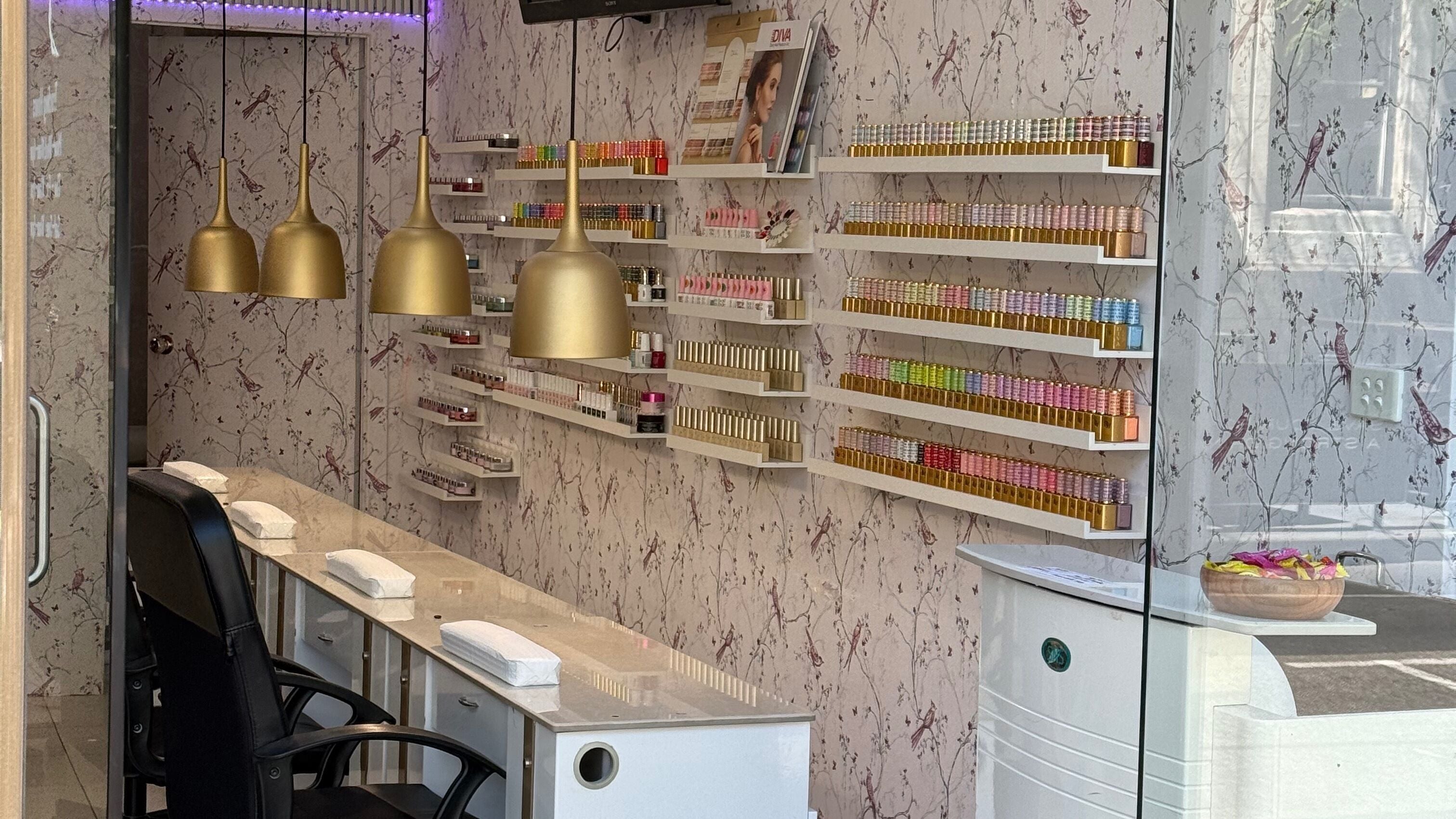 Elegant manicure station at Harmonia Beauty, Prahran, Victoria, AU, with nail polish display and golden lamps.