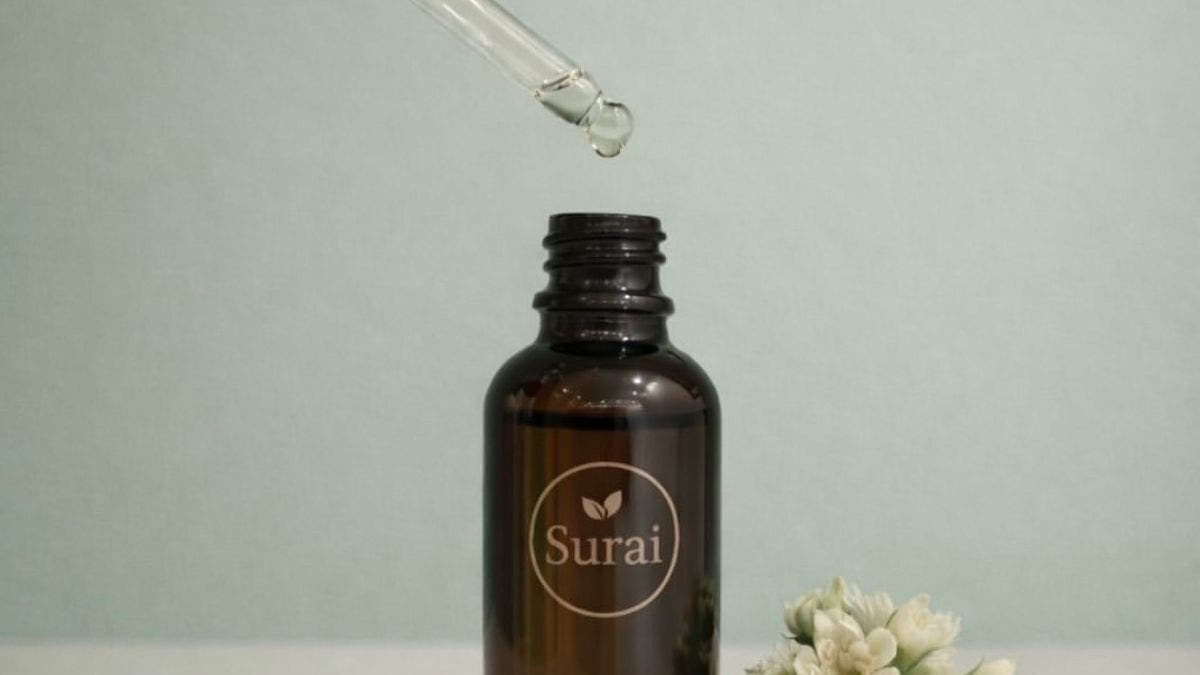Essential oil dropper above Surai Spa bottle in Riyadh, Riyadh Province, SA. Tranquil wellness scene.