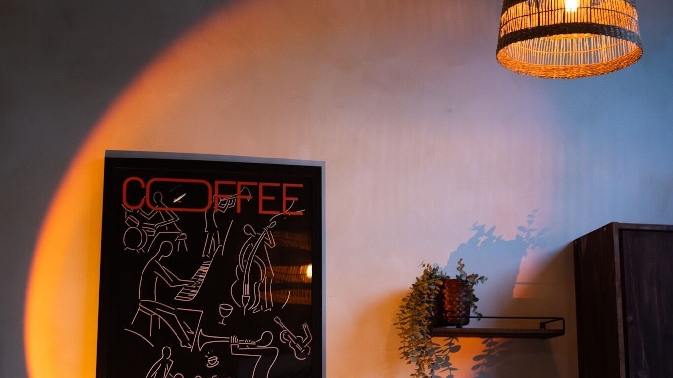Warm decor at HOUR. Studio, London, England with artistic coffee poster and ambient lighting.